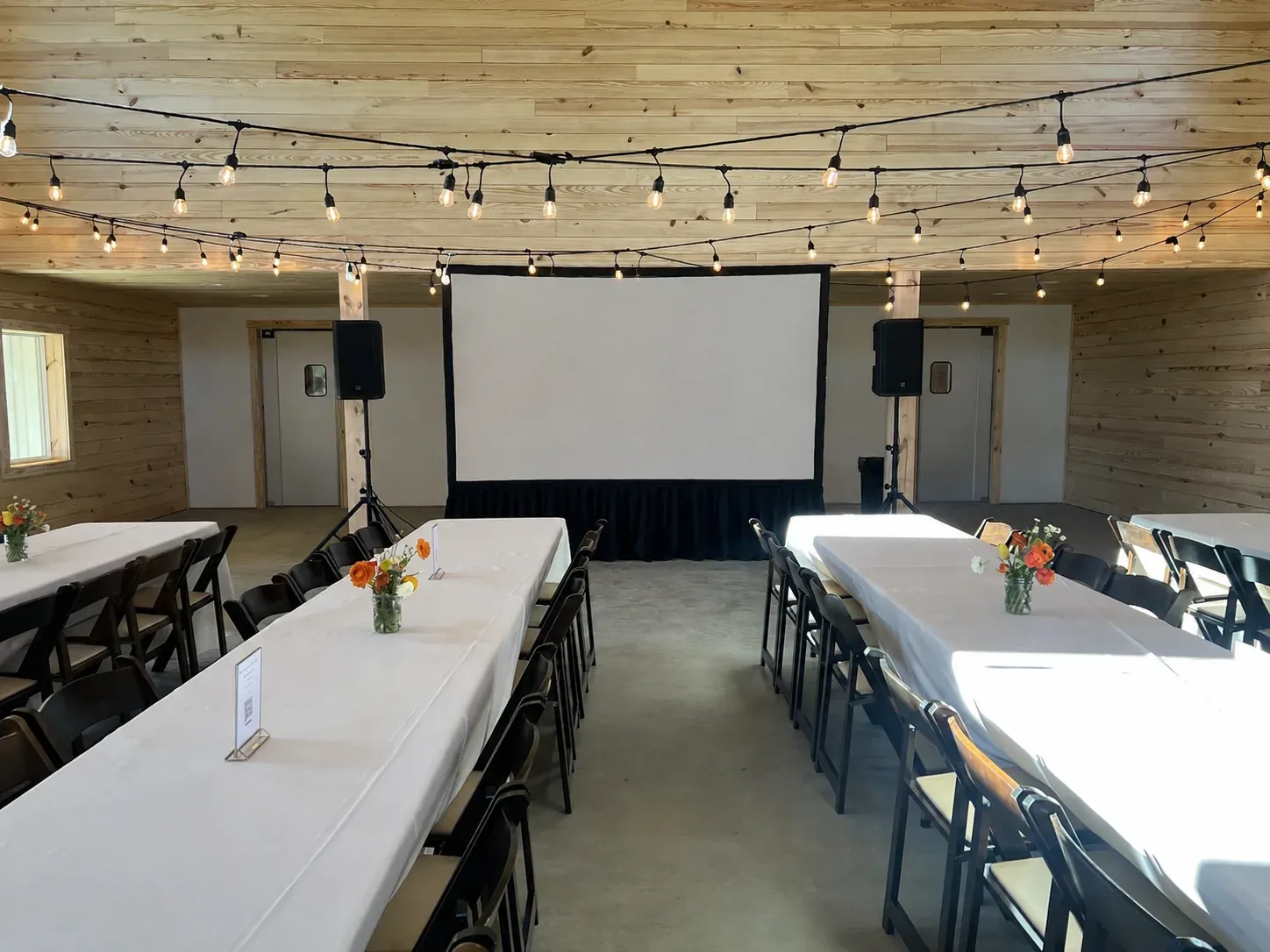 Indoor dining event with projection screen and audio setup