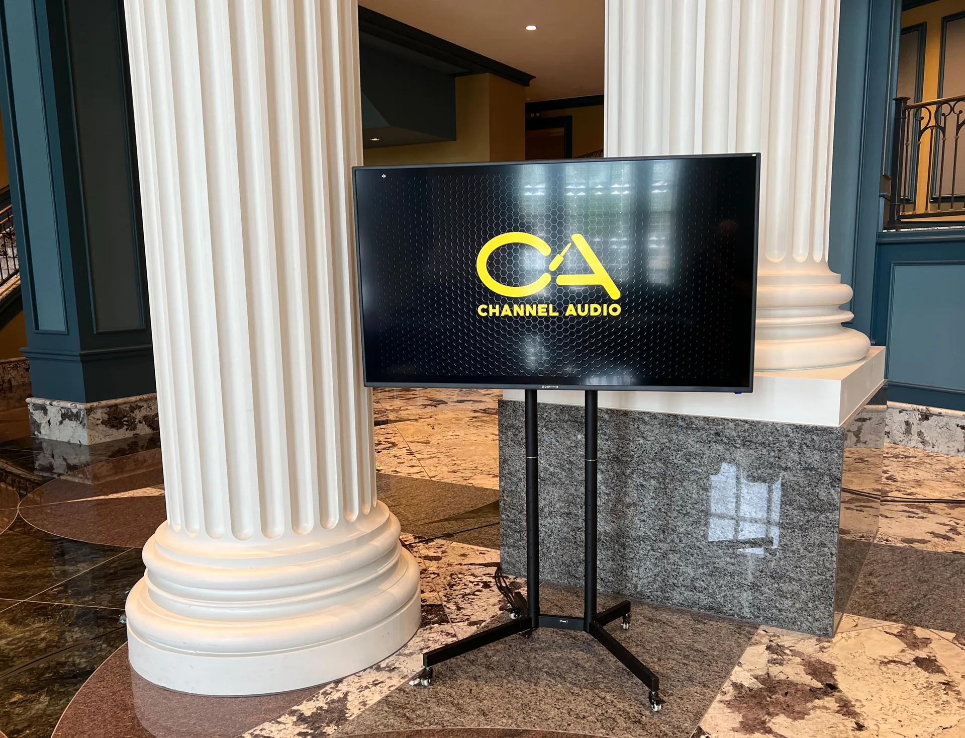 65-inch television mounted on floor stand at trade show booth exhibition