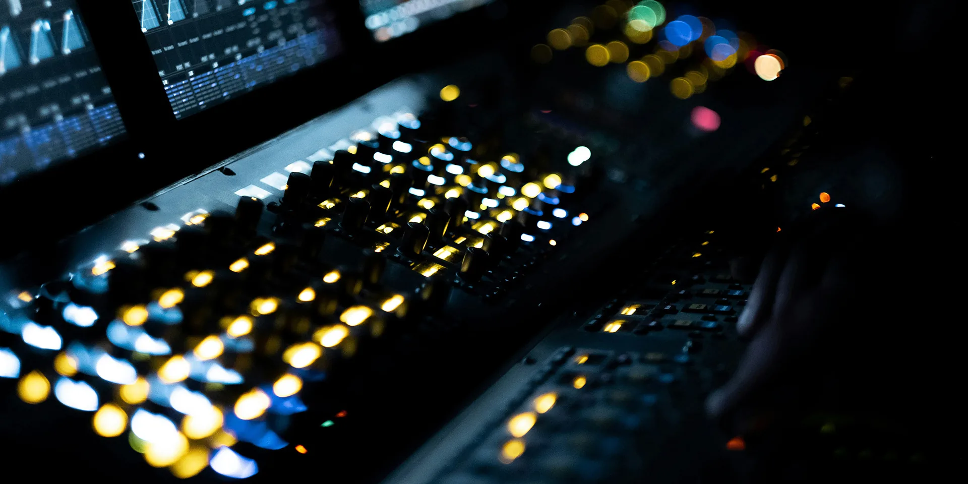 Close-up of audio mixer channel controls with illuminated knobs and signal level indicators