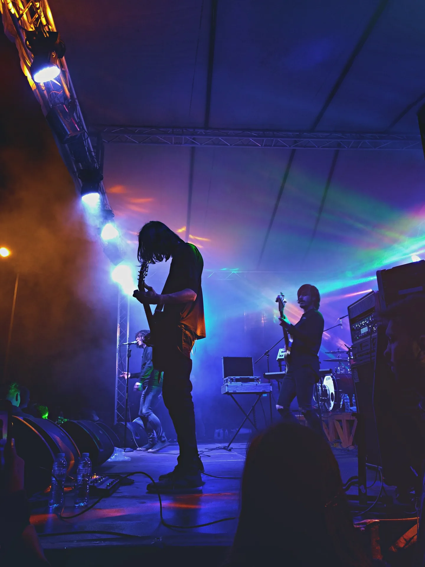 Live band performing on stage with wedge monitors visible at performers' feet