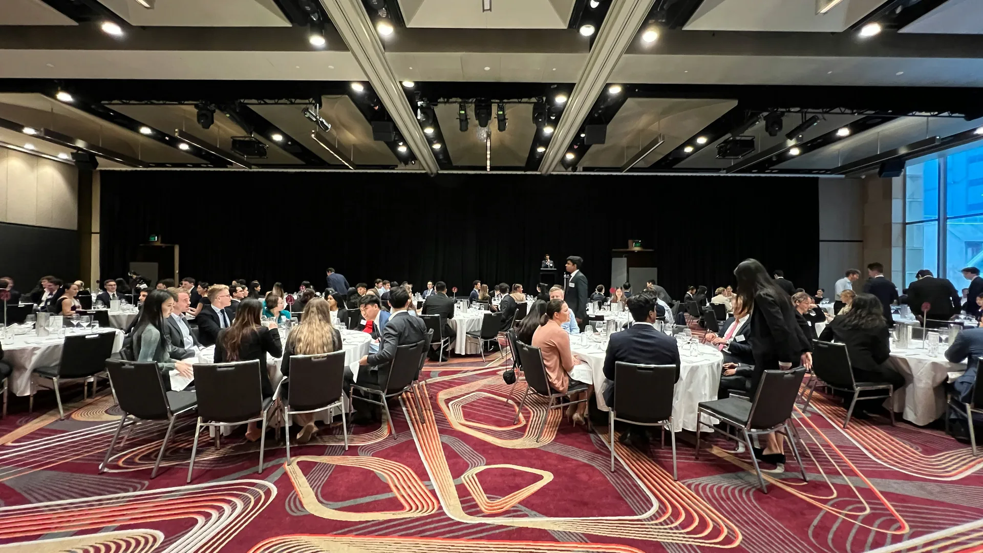 Banquet hall with stage, seating and integrated AV support configured for multi-room conference event