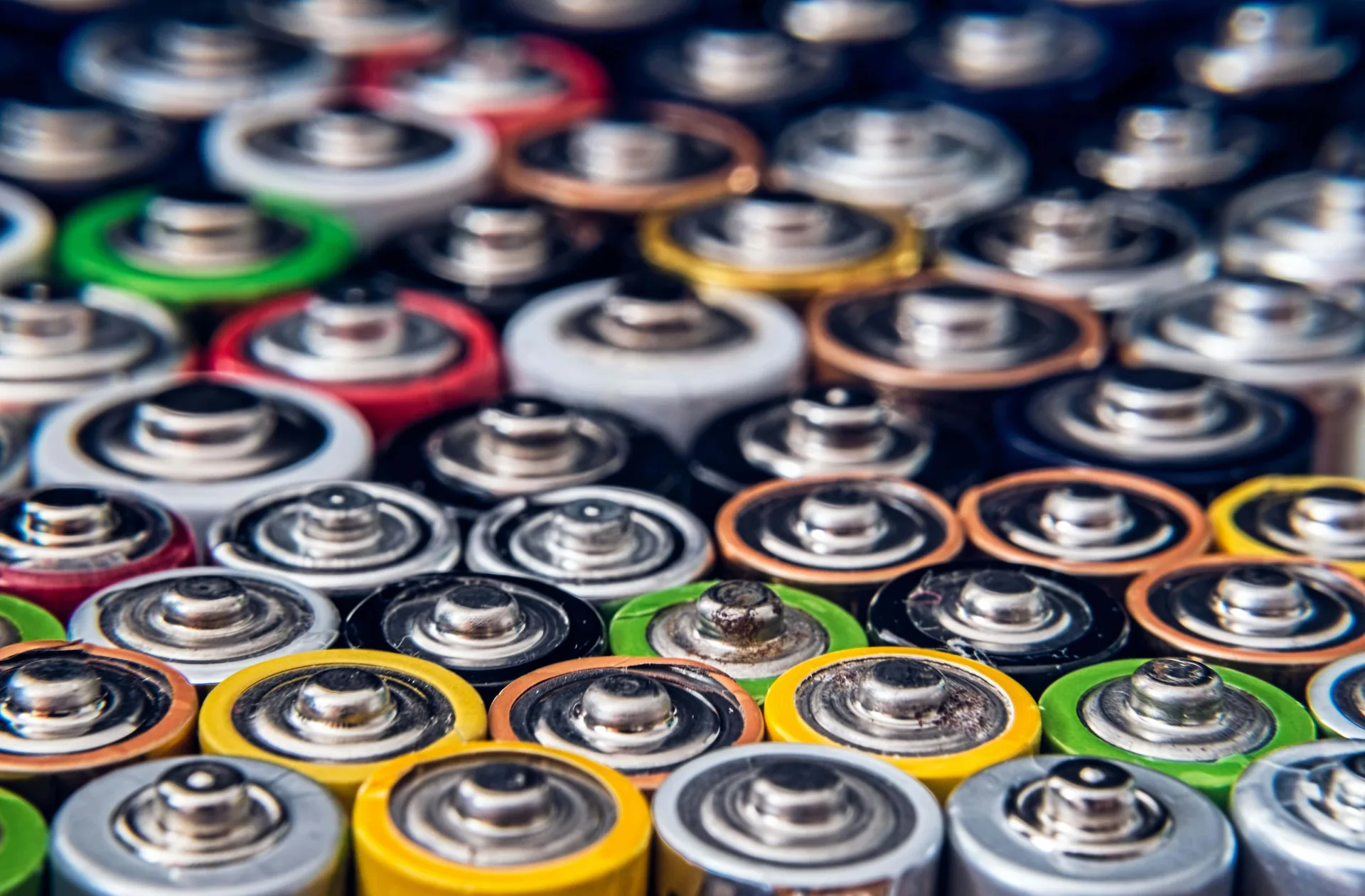 Close-up view of multicolored rechargeable batteries arranged in rows showing terminals