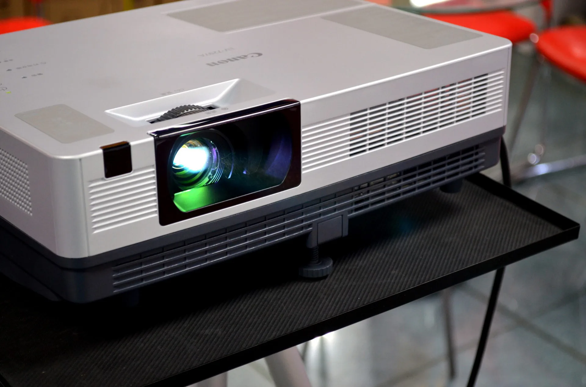 Canon silver projector on a table aimed at a projection screen at an event