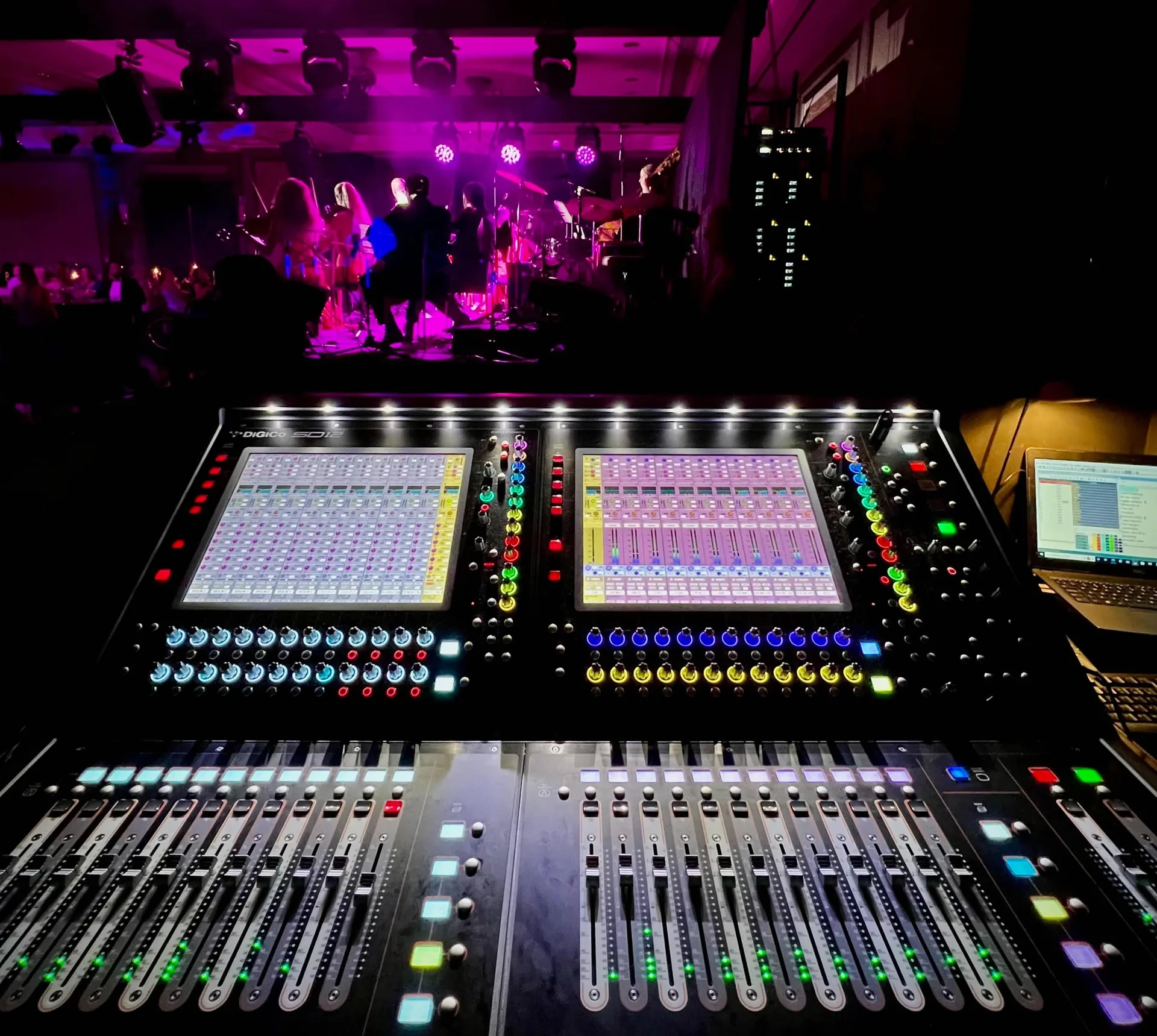 Professional digital mixing console being operated during a live performance at conference venue