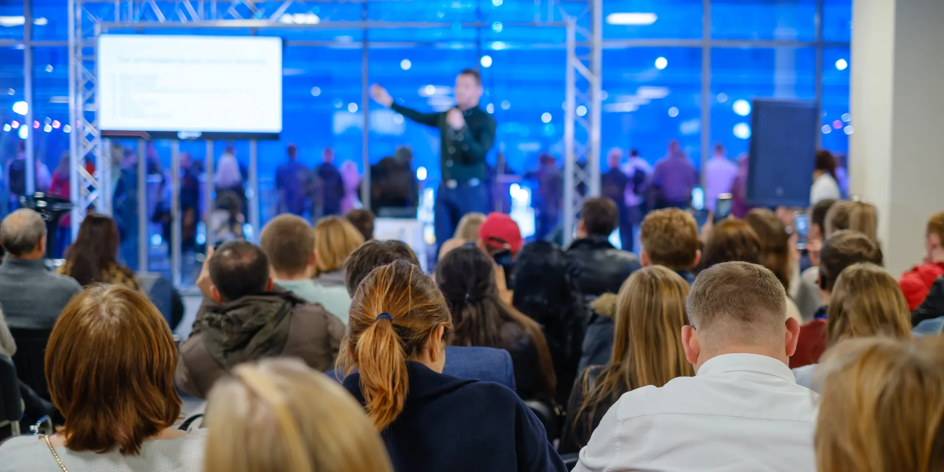 Corporate event audience viewing presentation content displayed from dedicated laptop