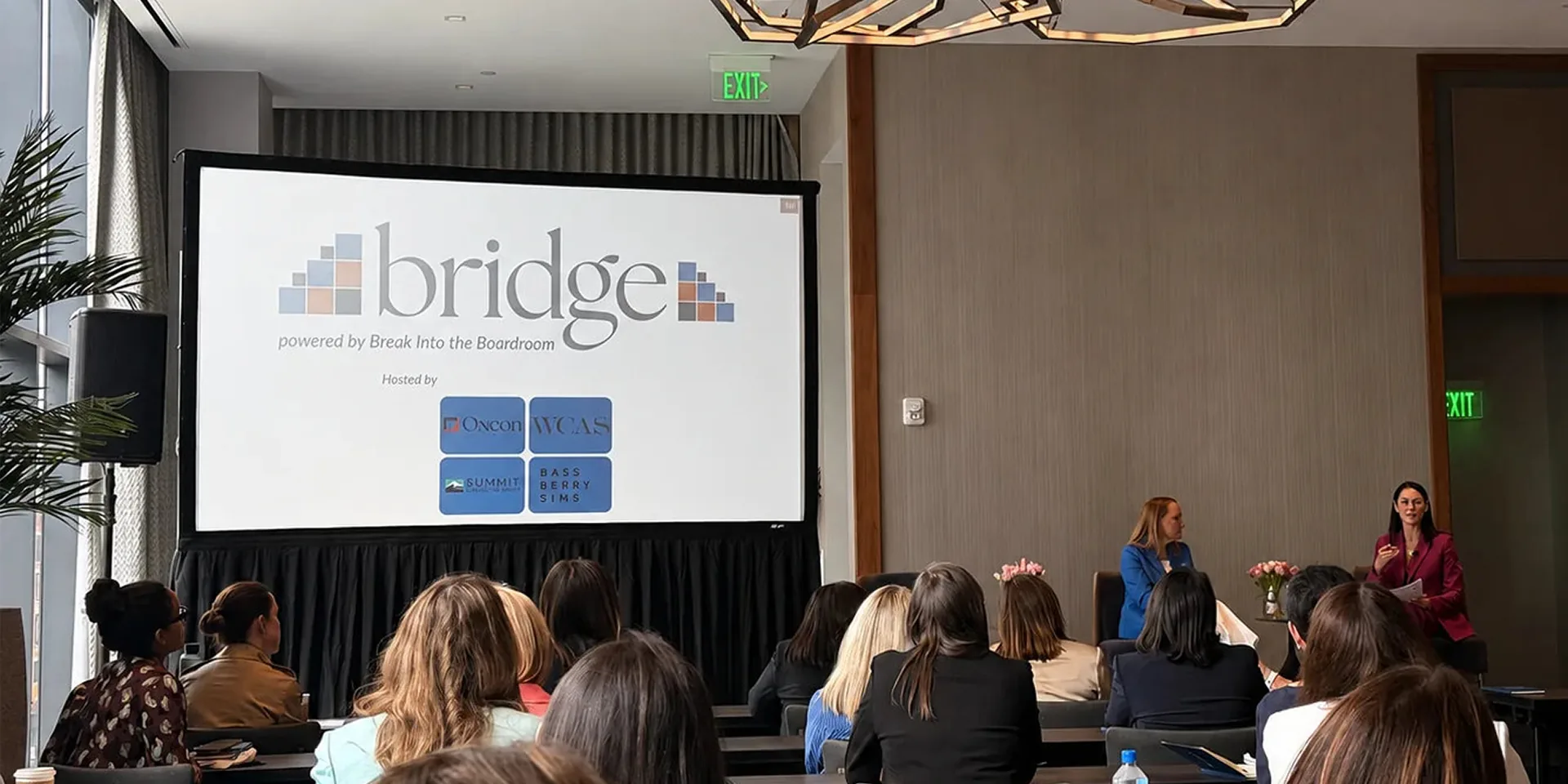 Corporate panel discussion at a Nashville conference with a large projection screen and PA speaker