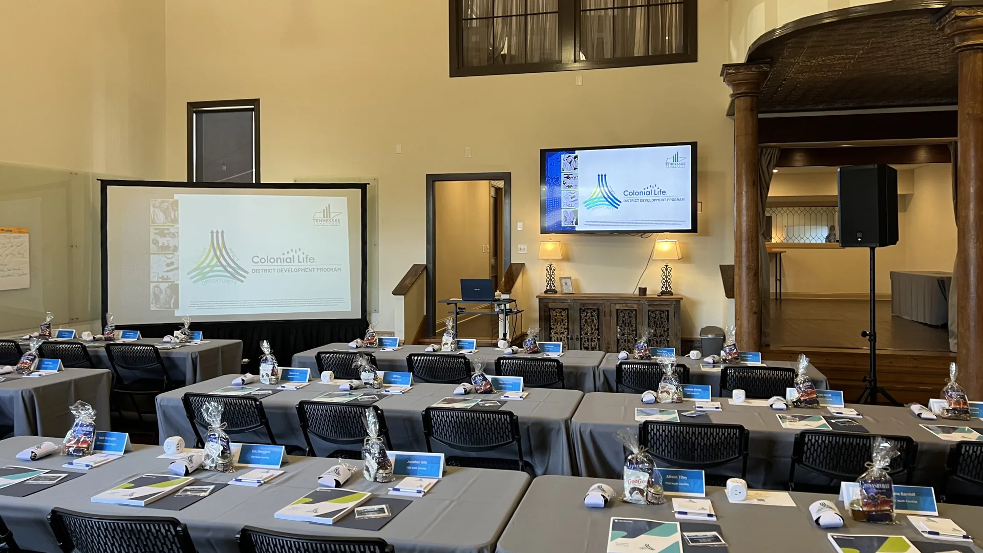 Corporate training room with projector screen, TV display and seating for multi-room breakout session