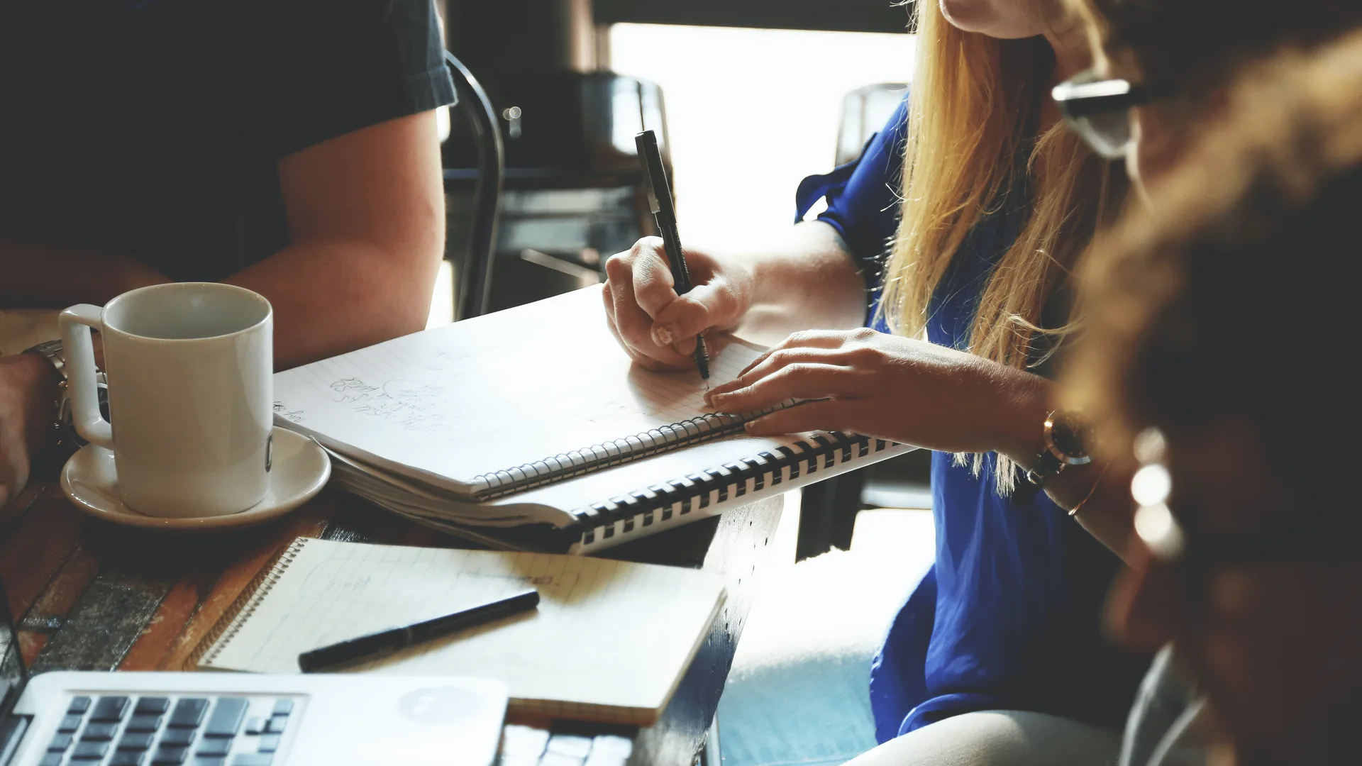 Event planner writing notes while touring an indoor venue space
