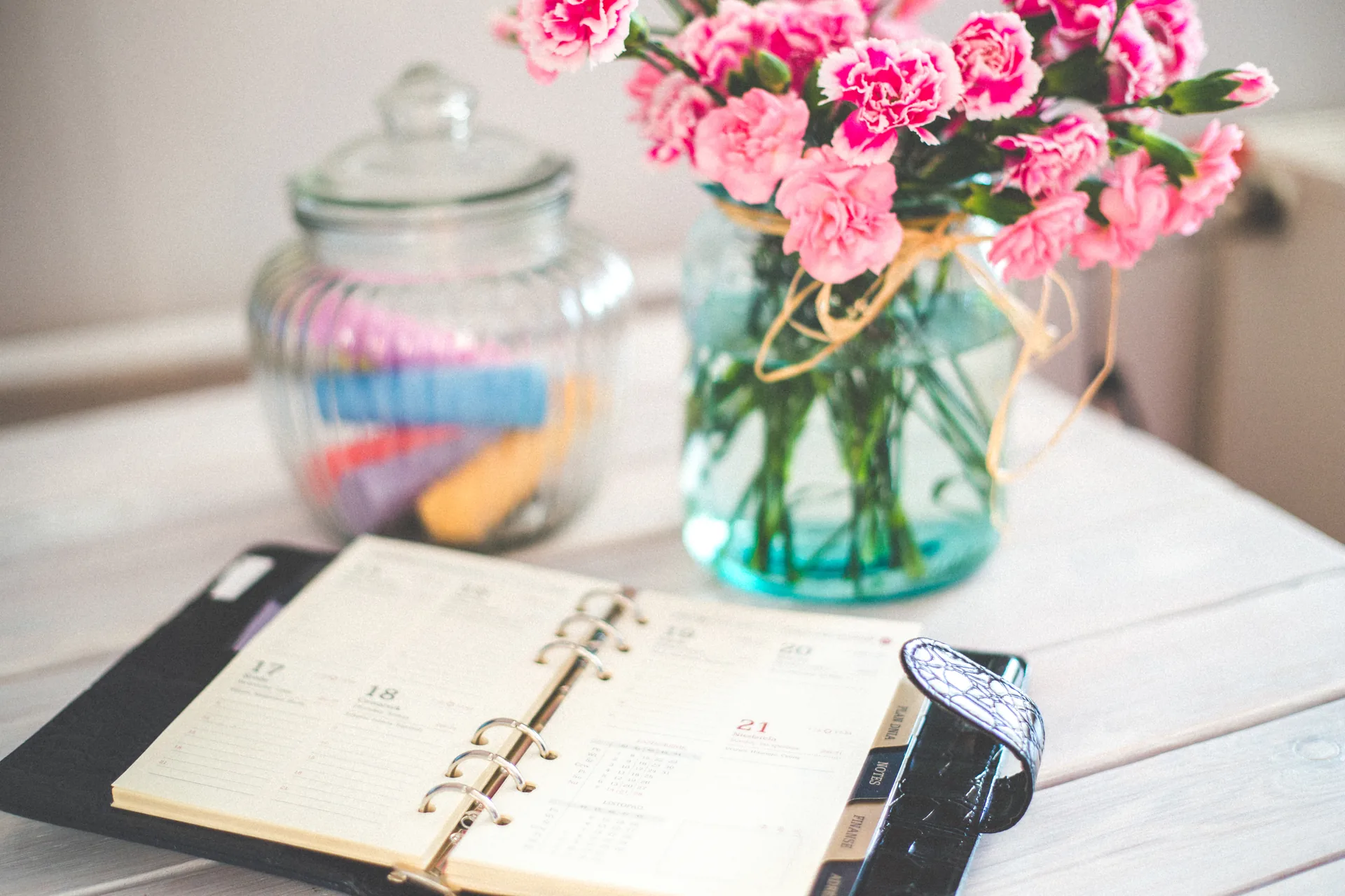 Event planner writing notes in a notebook at a table while preparing for an event