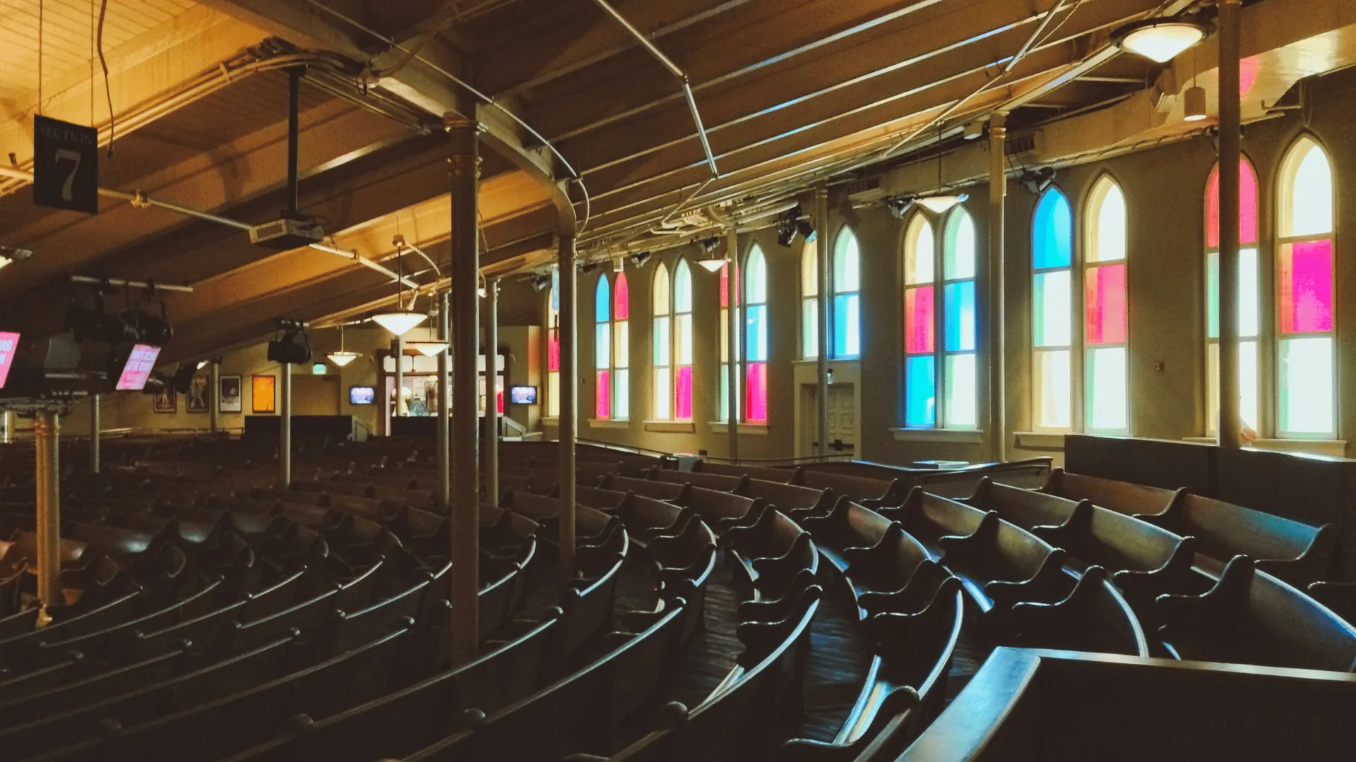 Illuminated stained glass windows in historic event venue showing architectural details