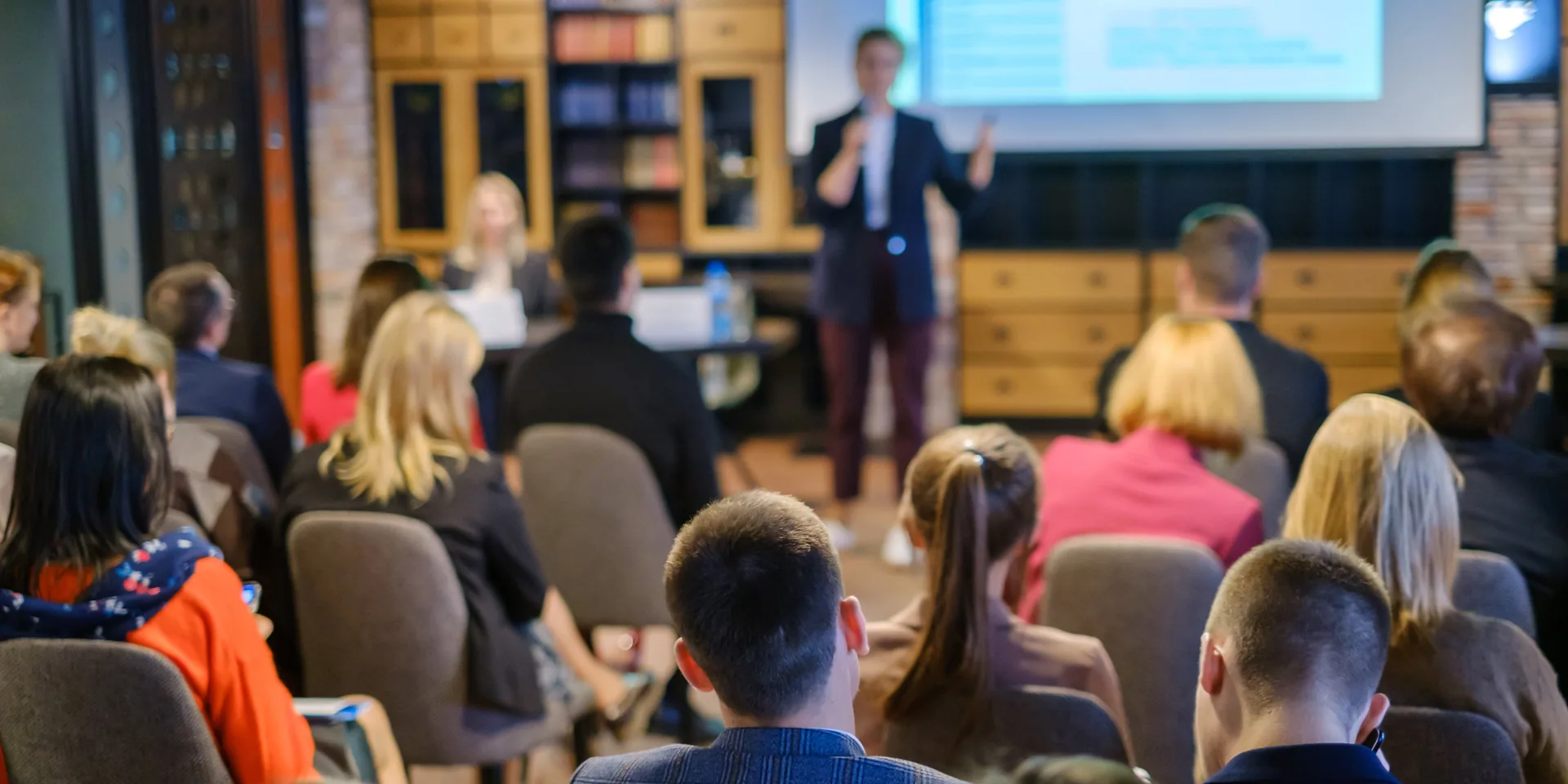 Business presentation attendees in accessible meeting space with clear sightlines and audio support systems in place