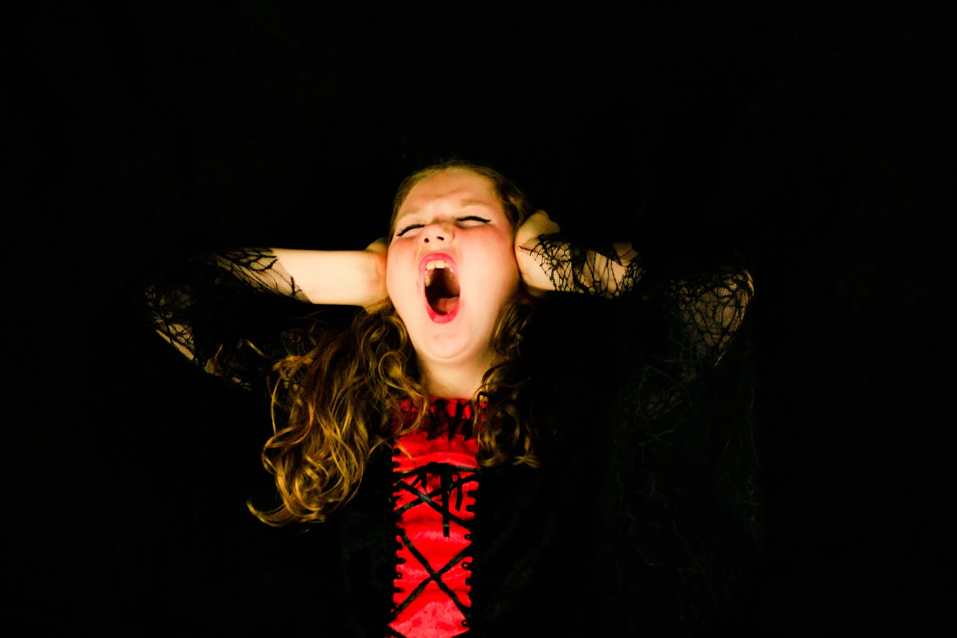 Young girl covering her ears and screaming with eyes closed, illustrating the stress of things going wrong at an event