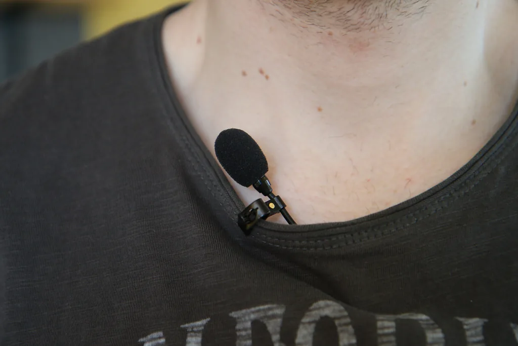 Lavalier microphone clipped to a presenter's collar for hands-free event audio