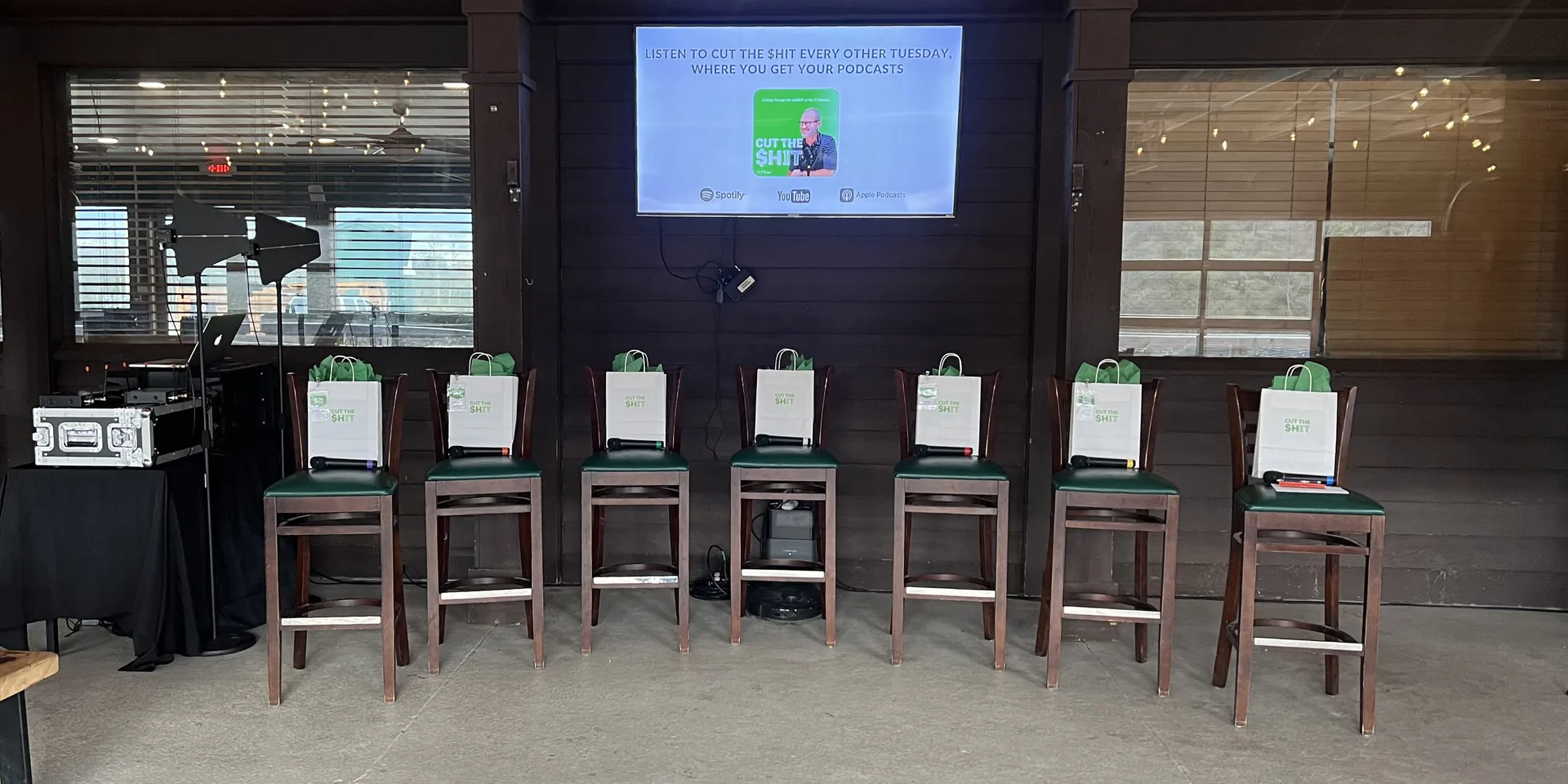 Panel discussion with wireless microphones, stools and display screen for live event audio recording