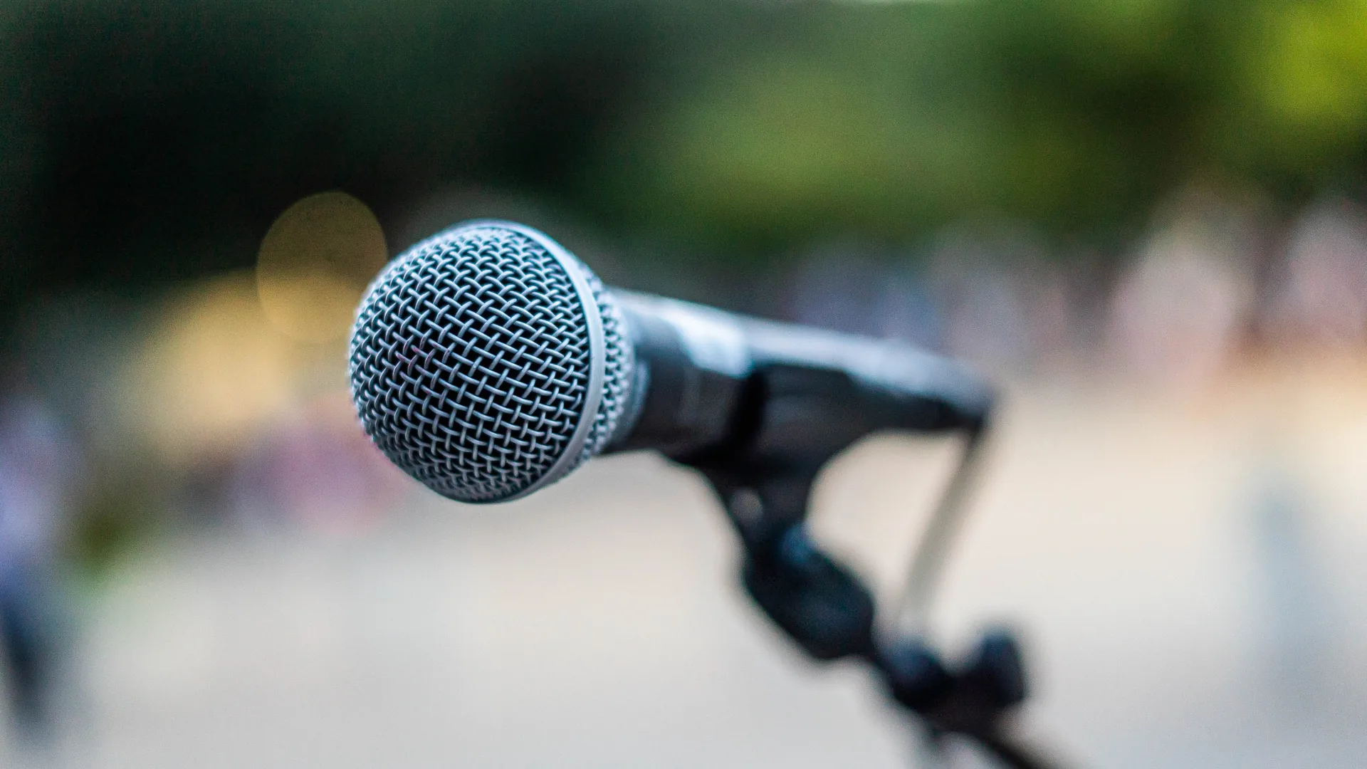 Close up of microphone on stand with blurred background in live performance setting