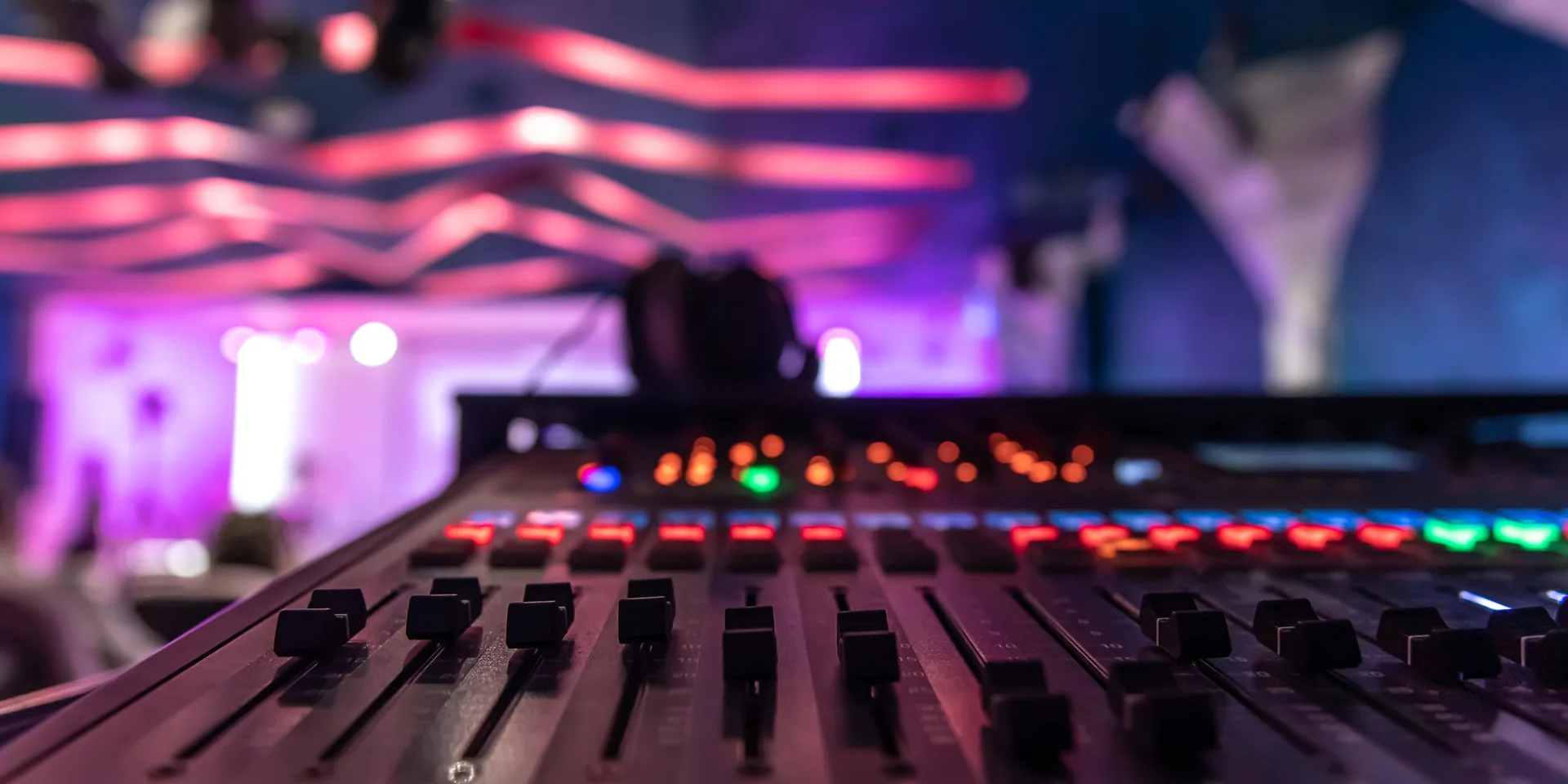 Illuminated live sound board controls during corporate event audio recording and mixing