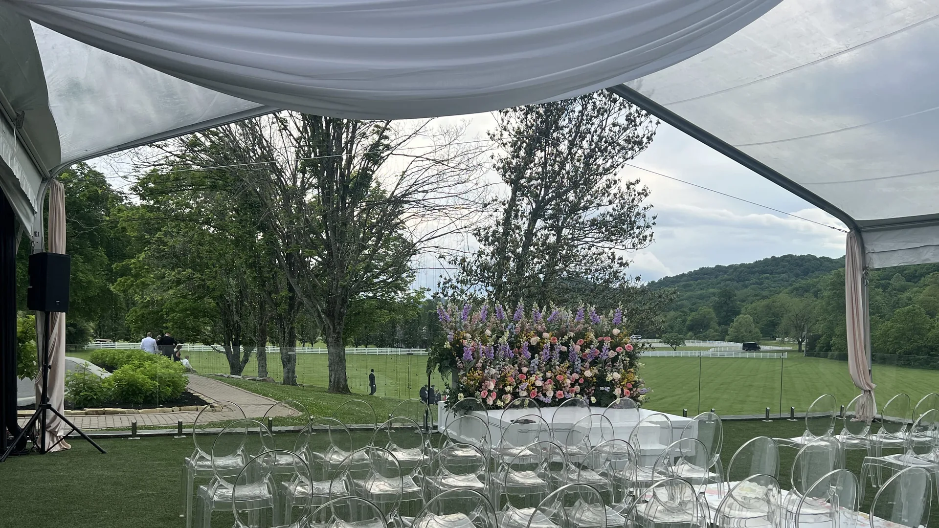 Wedding ceremony under tent with professional audio equipment and microphones installed