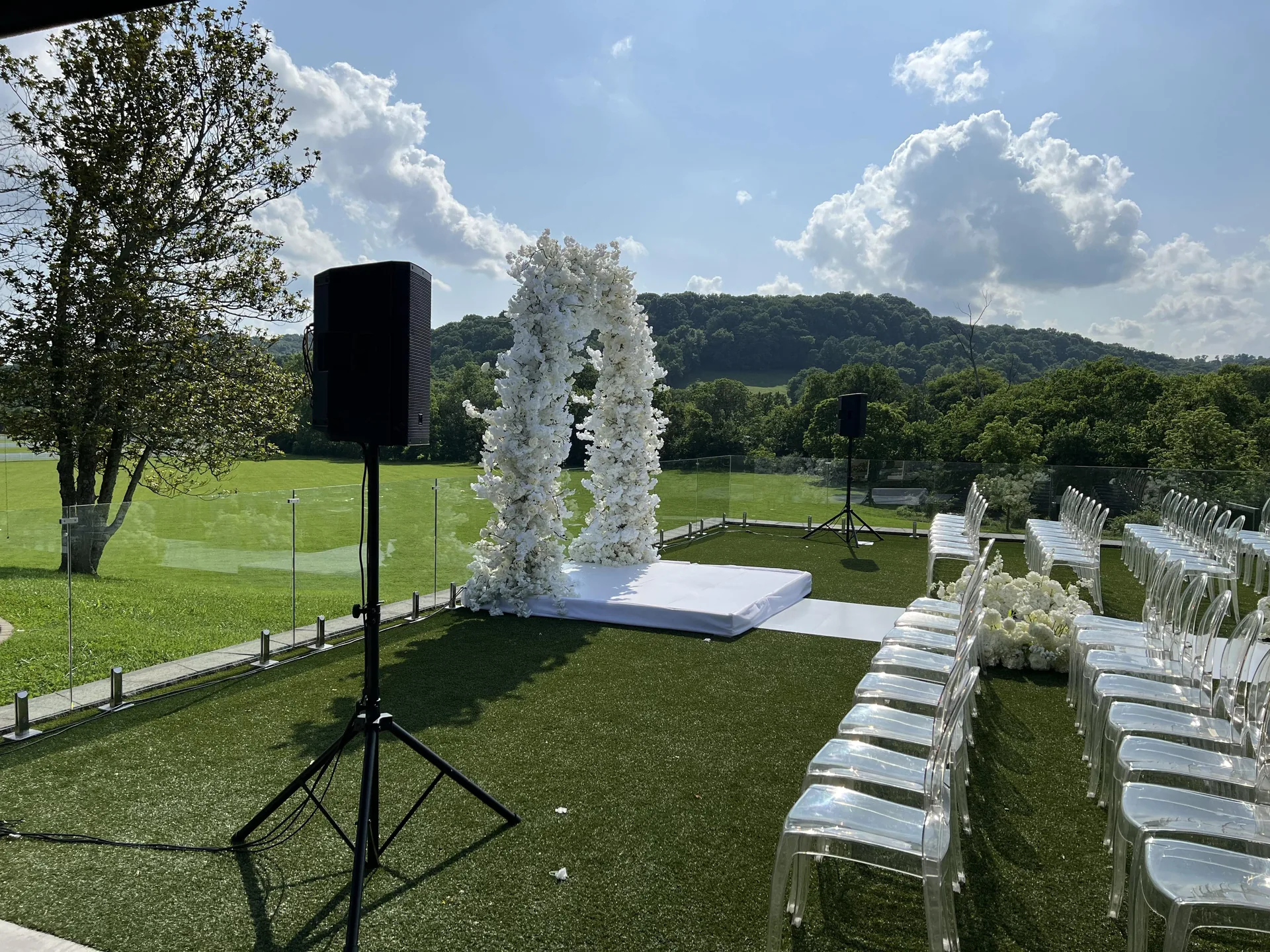 Outdoor wedding venue showing floral arch and guest seating arrangement for ceremony