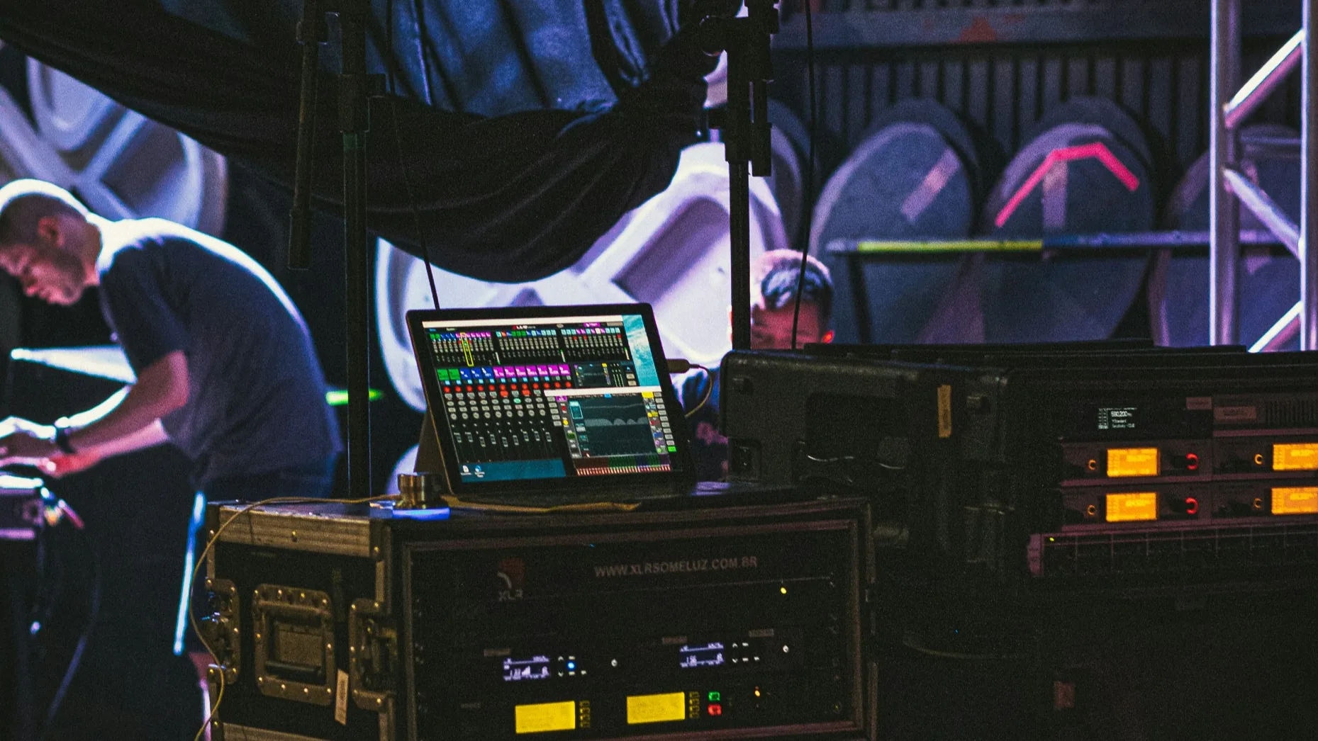 Professional rackmount audio equipment and cables arranged backstage for event