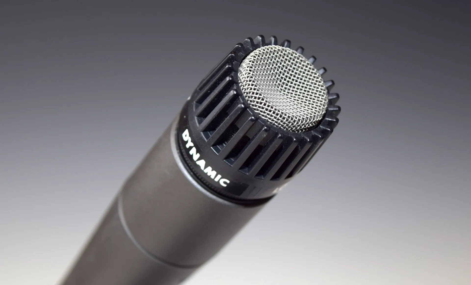 Close-up of Shure SM57 dynamic microphone head showing the mesh grille and capsule housing