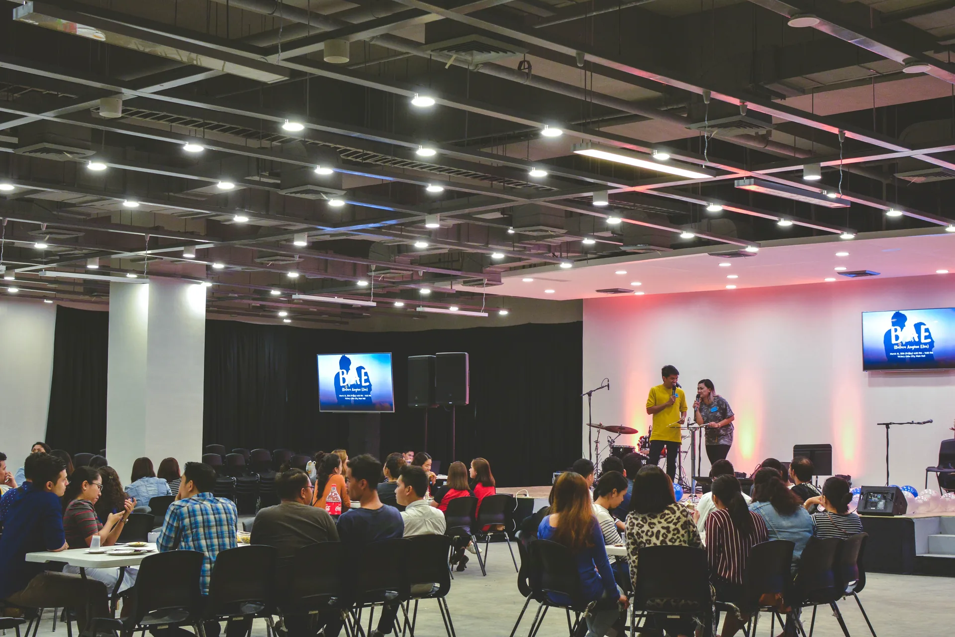 Small stage setup at a trade show or business event with speakers and audience