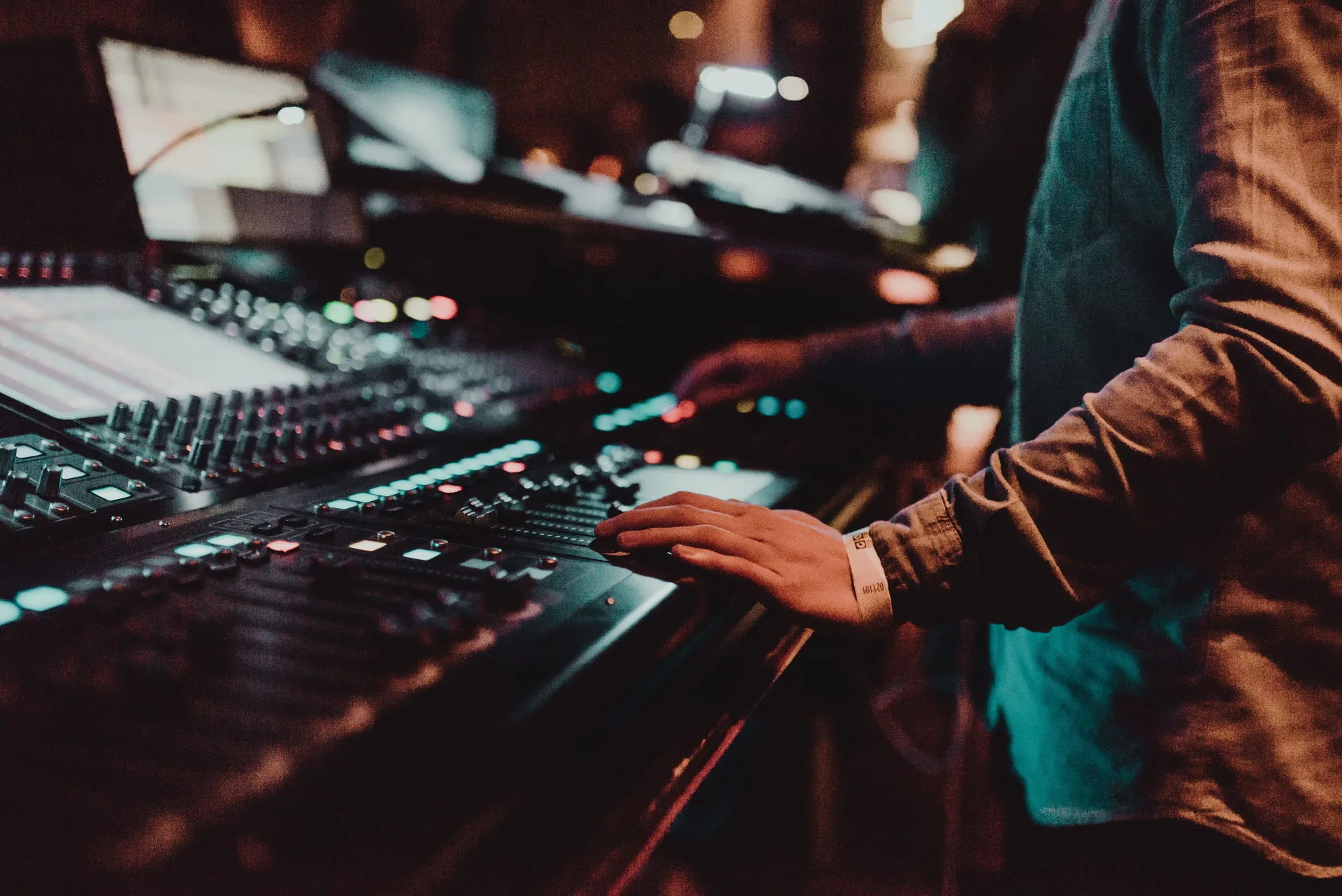 Sound technician adjusting controls on audiovisual equipment during event