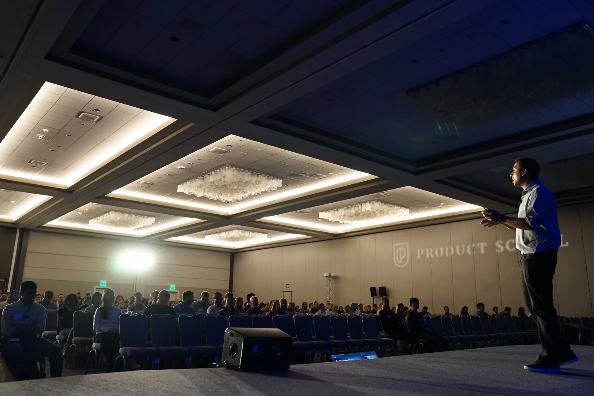 Speaker wearing a wireless lapel microphone talking to event attendees at a corporate event