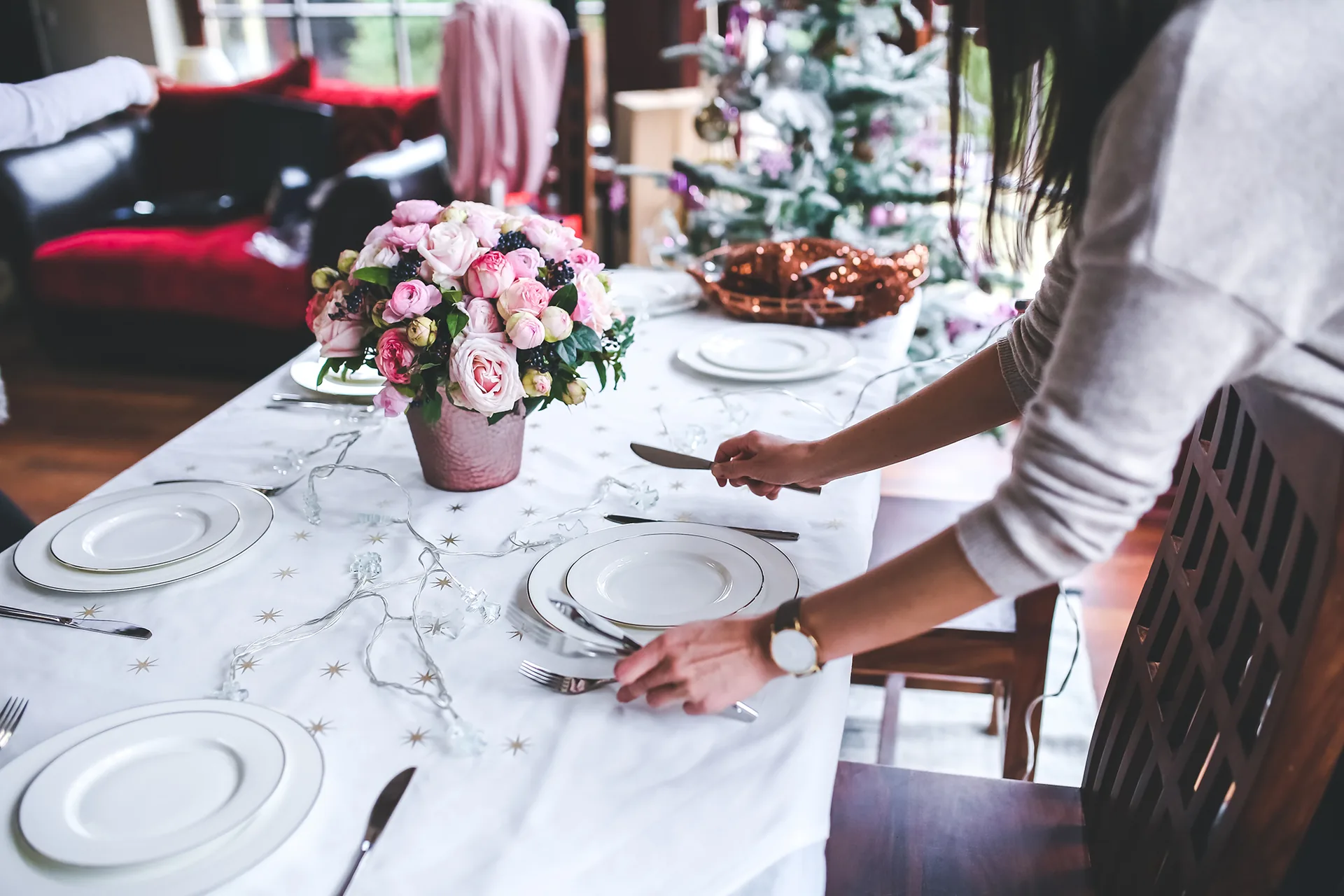 Wedding planner arranging a table at a reception venue ahead of the ceremony
