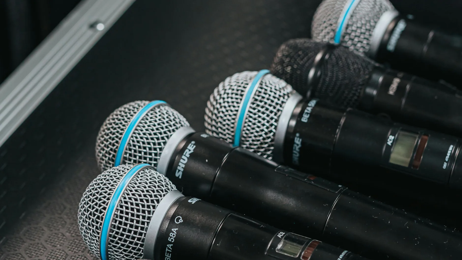 Collection of wireless microphones in hard case ready for deployment during live event