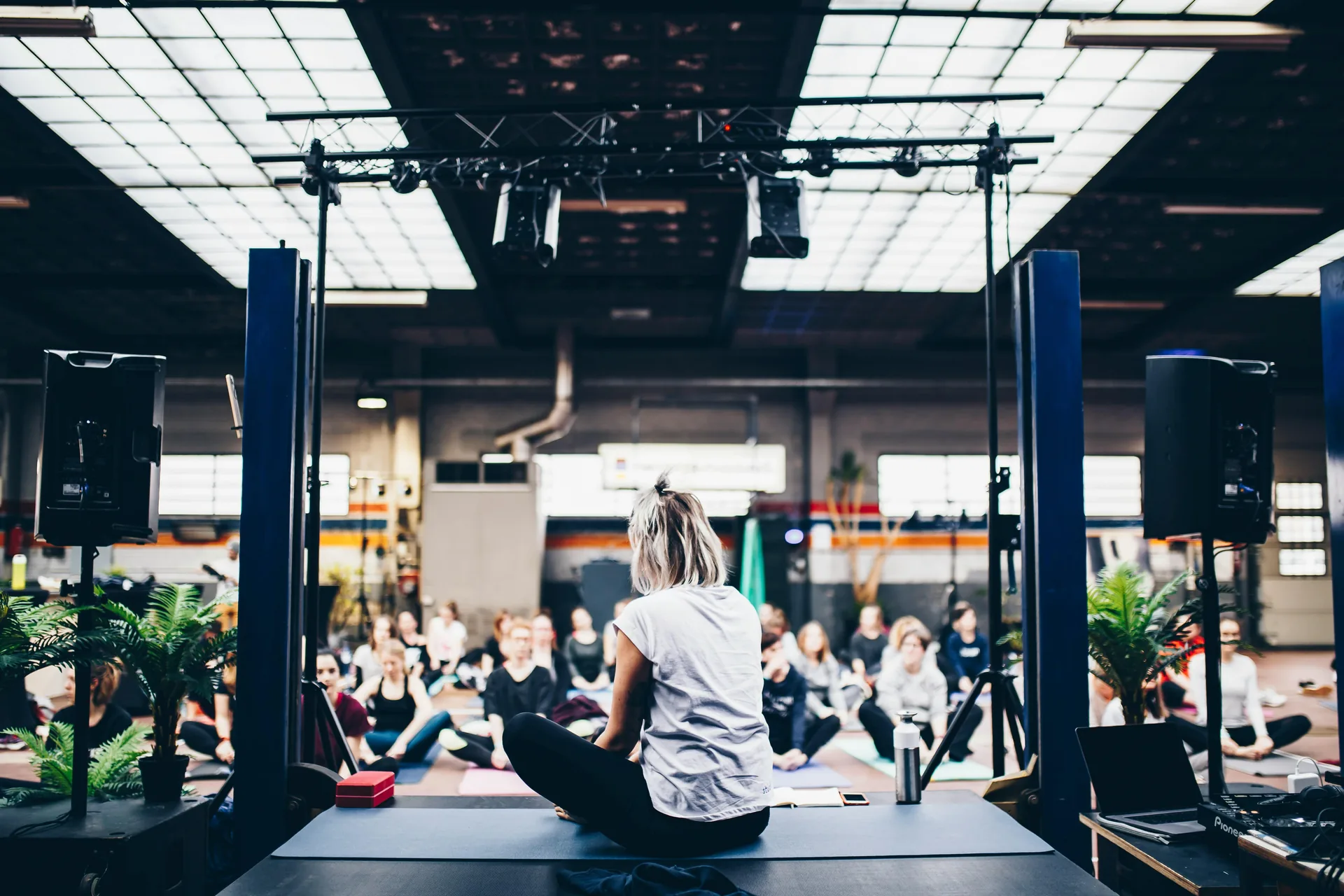 Spacious yoga studio with speaker system mounted on truss structure for audio support