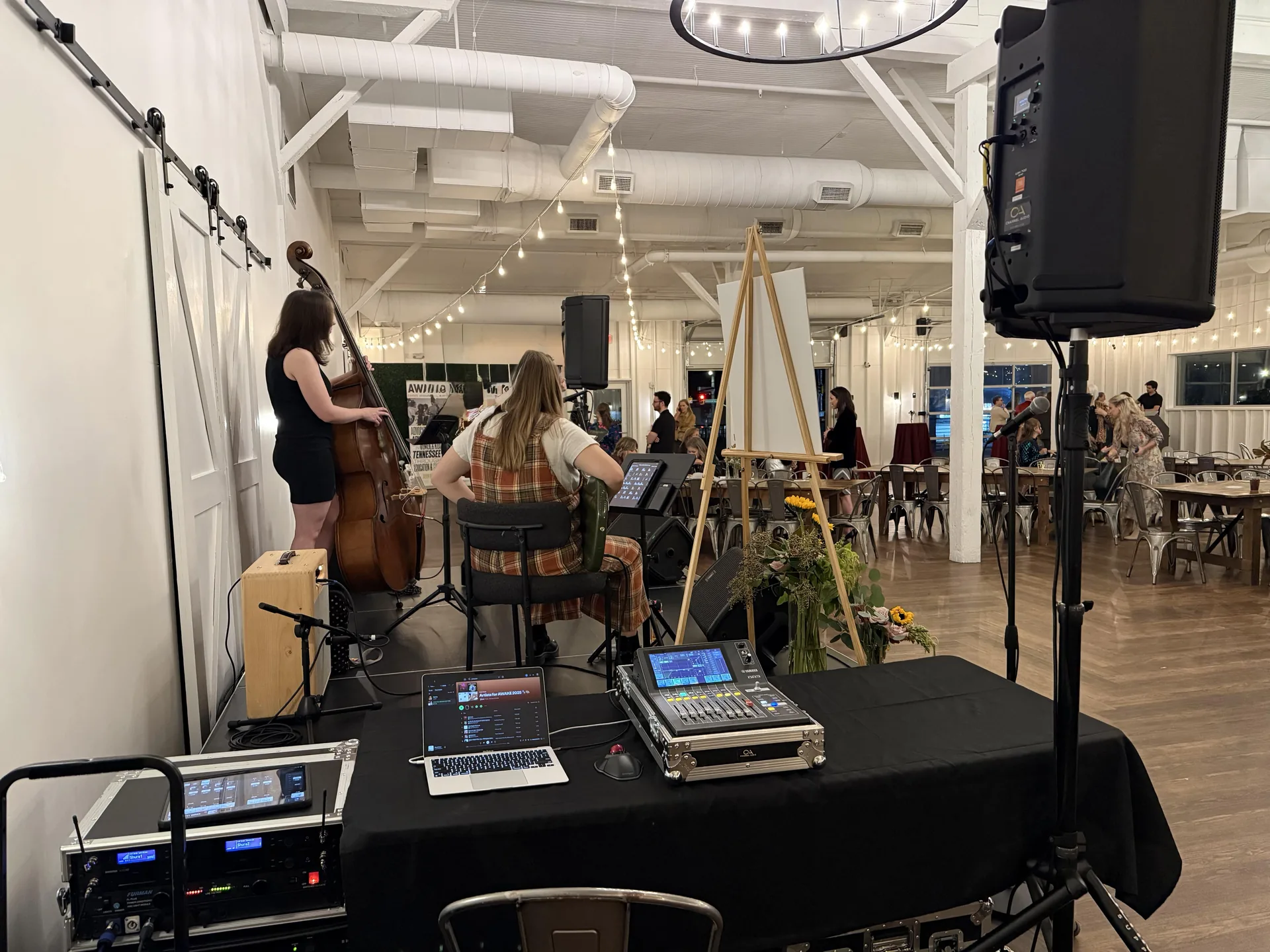 Audio mixing setup and sound engineer view during live band performance at Artists for AWAKE event