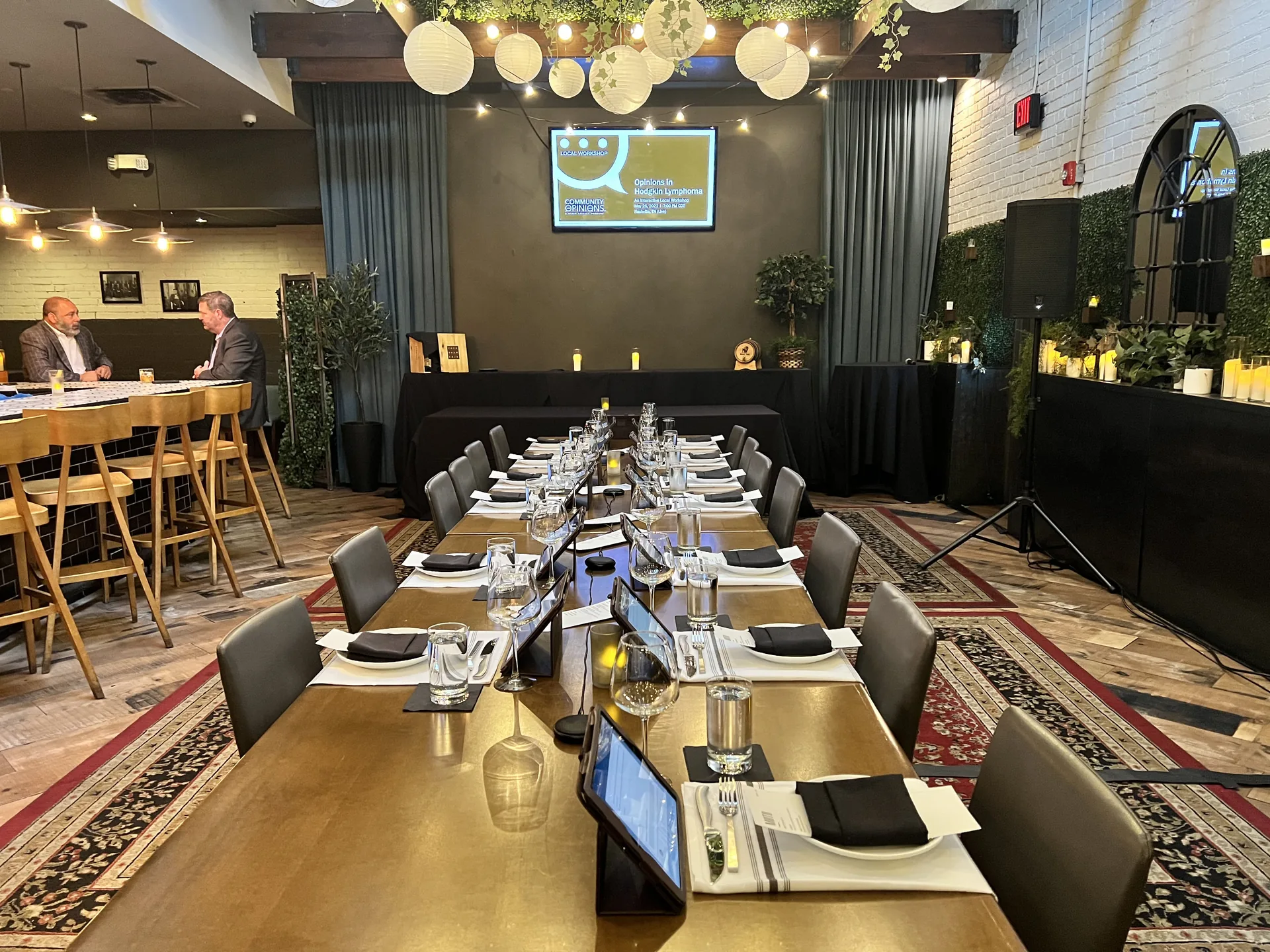 Business dining event with a PA audio setup beside a long table in a decorated restaurant