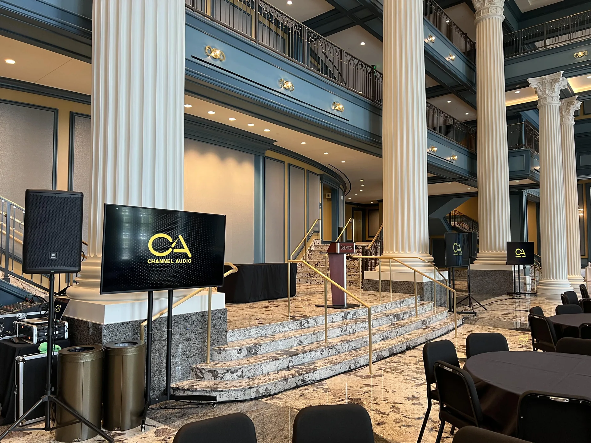 Channel AV TV display and PA speaker setup in a grand lobby with classical columns