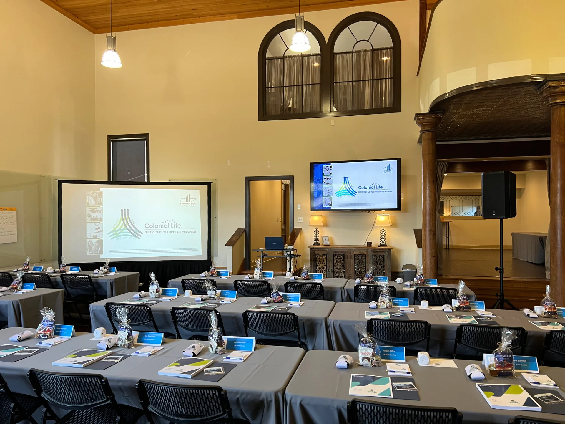 Conference room with a Colonial Life presentation on a projection screen and an event audio system