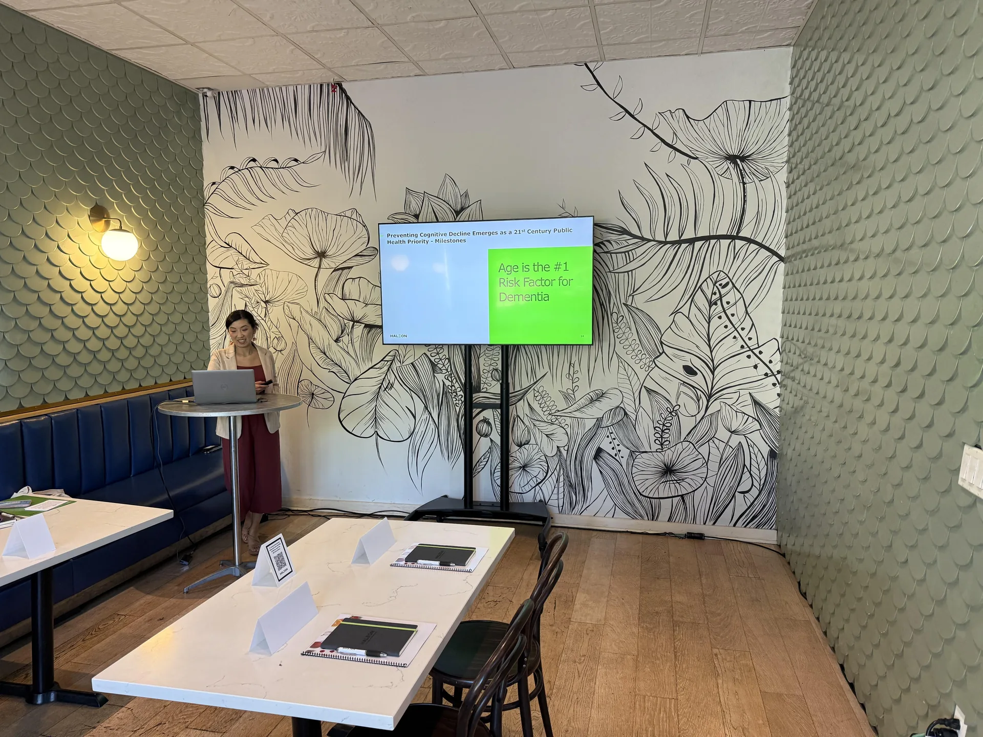 Corporate presentation setup with large TV display, laptop, and presenter in Nashville meeting space