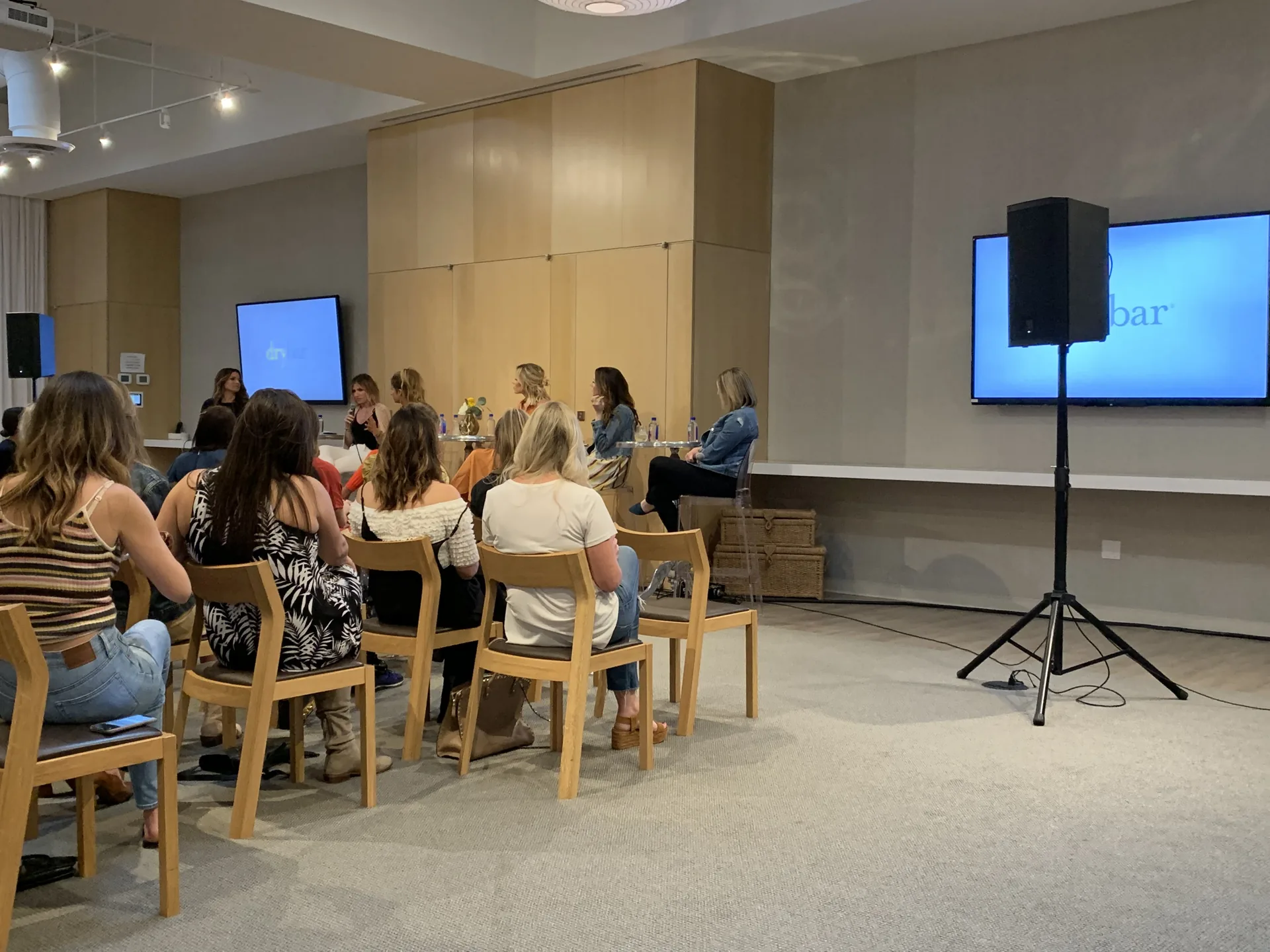 Panel discussion at Drybar with microphones, PA audio support and an audience in a modern conference room