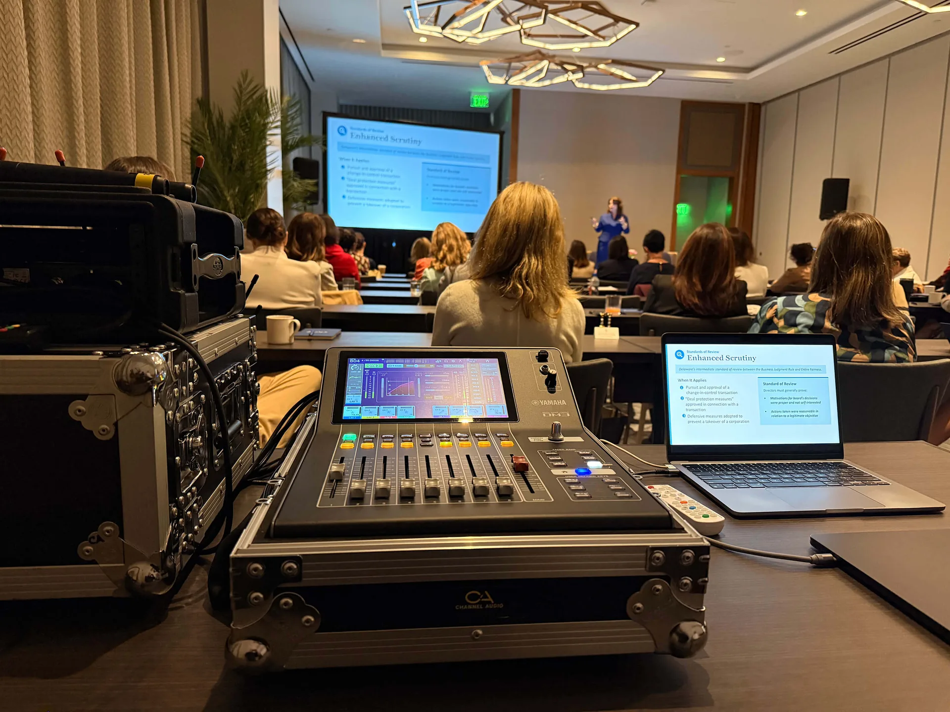 Audio mixing console and laptop controlling the sound system and projected visuals for a live event