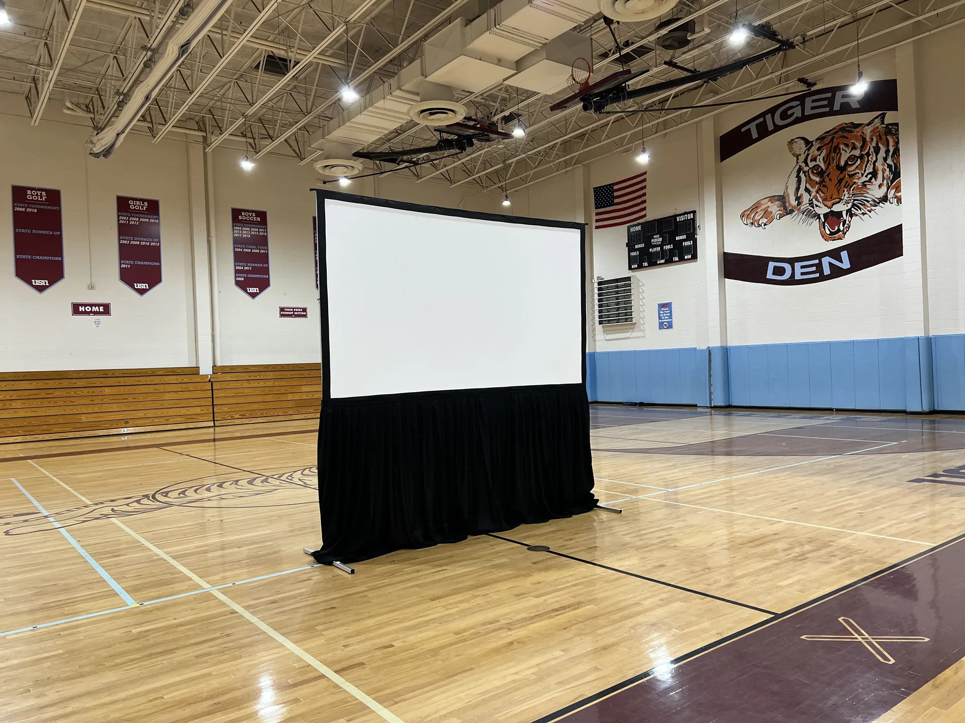 Gymnasium converted into an auditorium with a large projection screen for a presentation