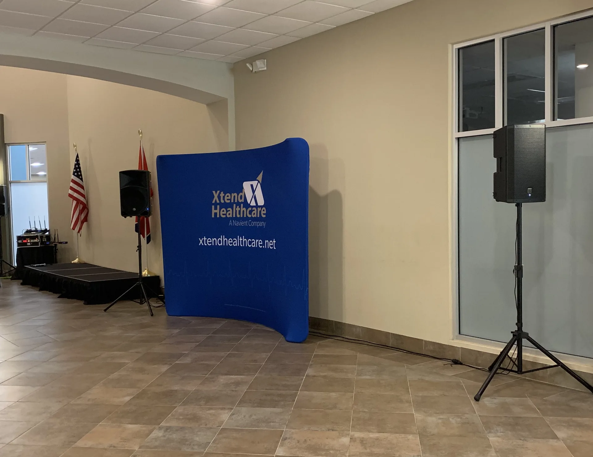 Xtend Healthcare event with a stage, banner and PA audio equipment