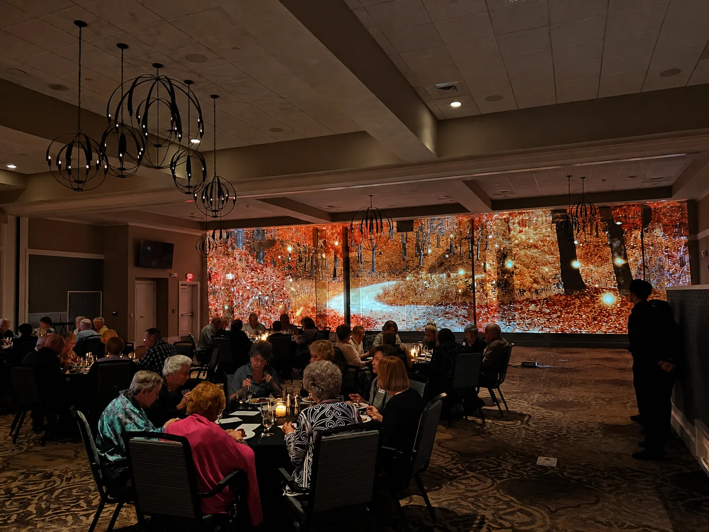 Immersive autumn foliage projection displayed across ballroom walls during an indoor event