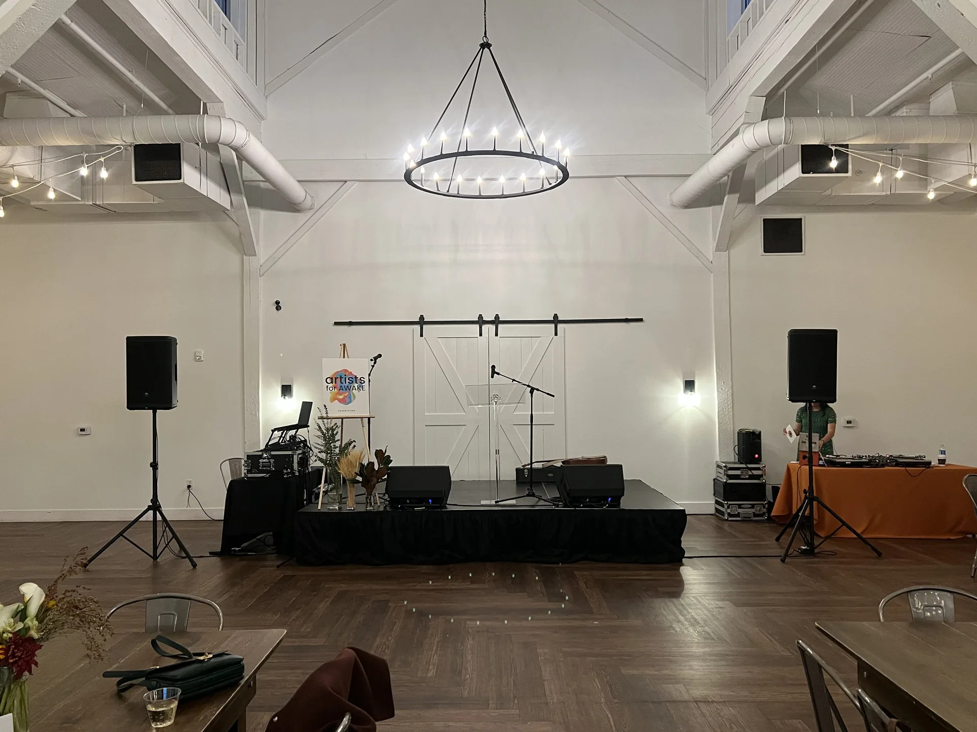 Indoor event stage with PA speakers, floor monitors, microphones and audio equipment