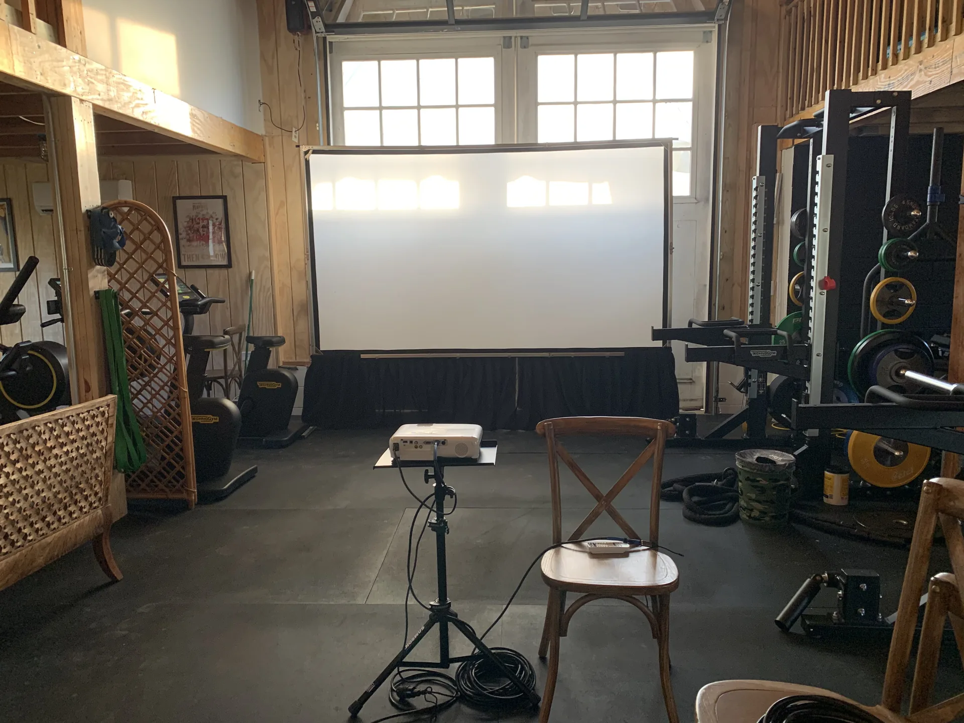 Indoor gym converted into a presentation area with a large projection screen and audience seating