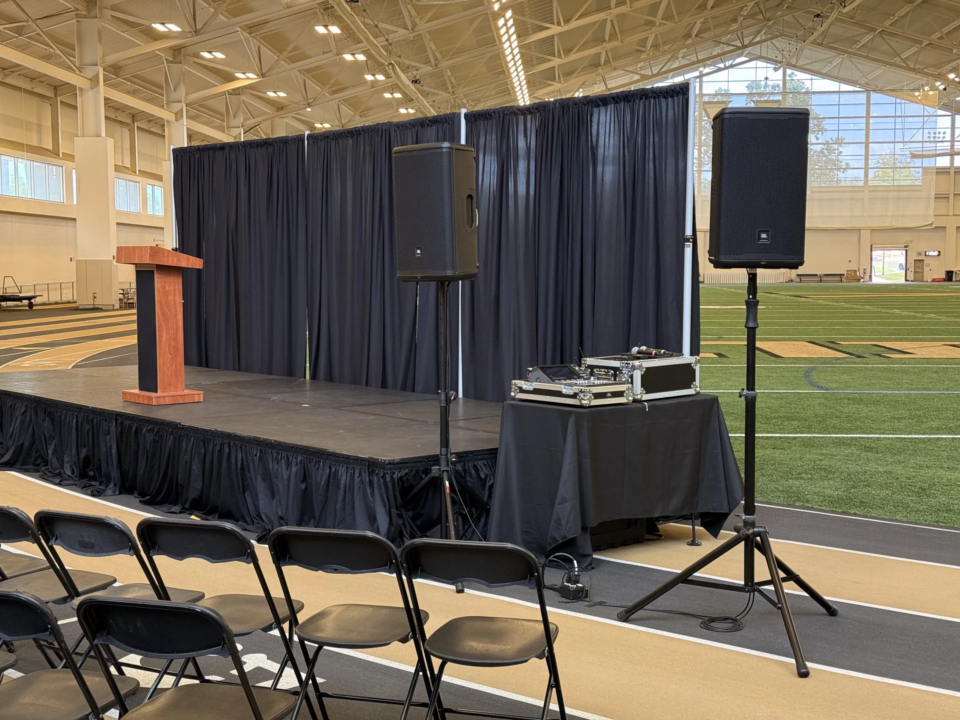 Large corporate event setup with stage, podium, PA speakers and audience seating at an indoor venue in Nashville