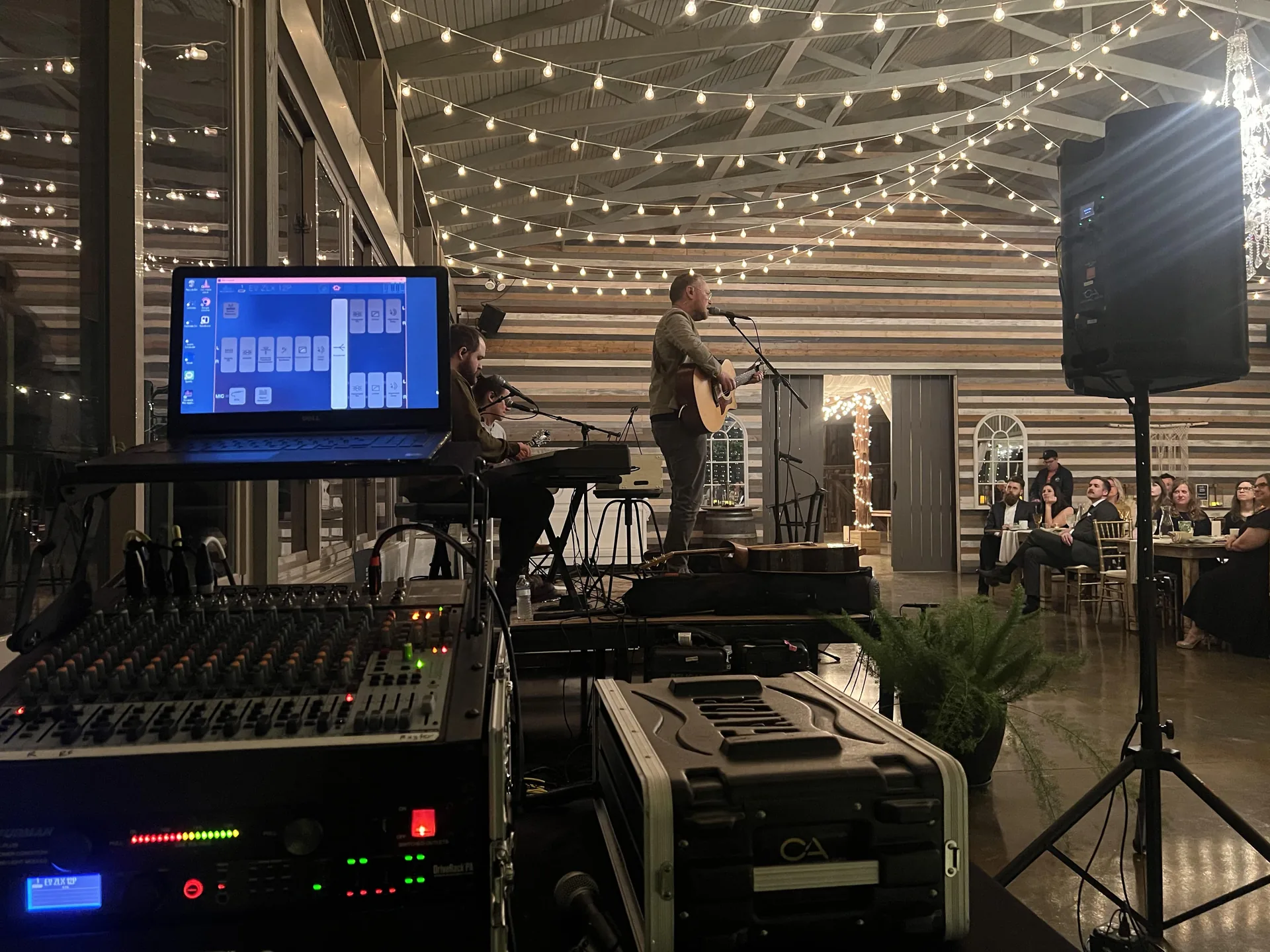 Live music performance setup with audio equipment and a singer on stage