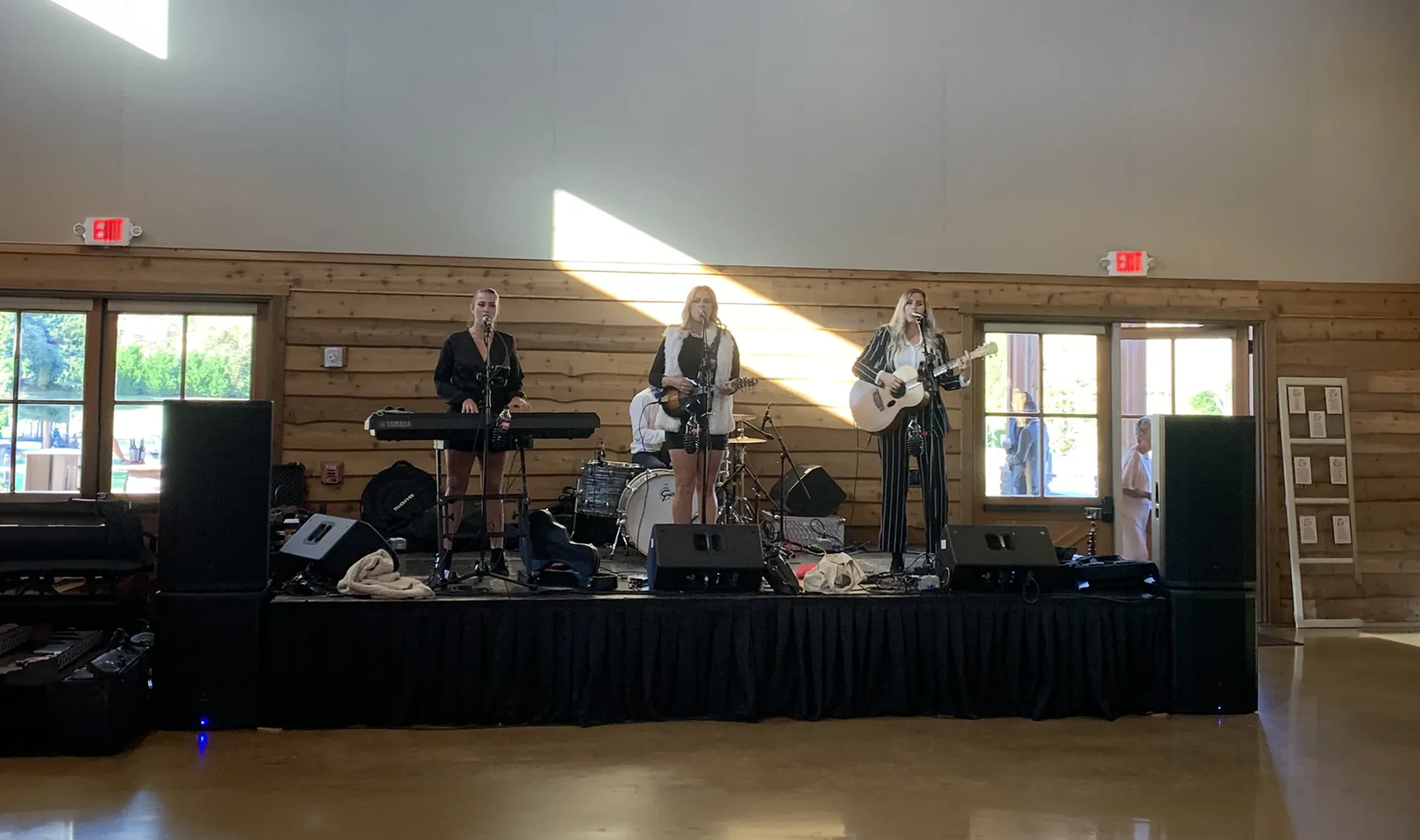A band performing on stage with speakers and instruments visible