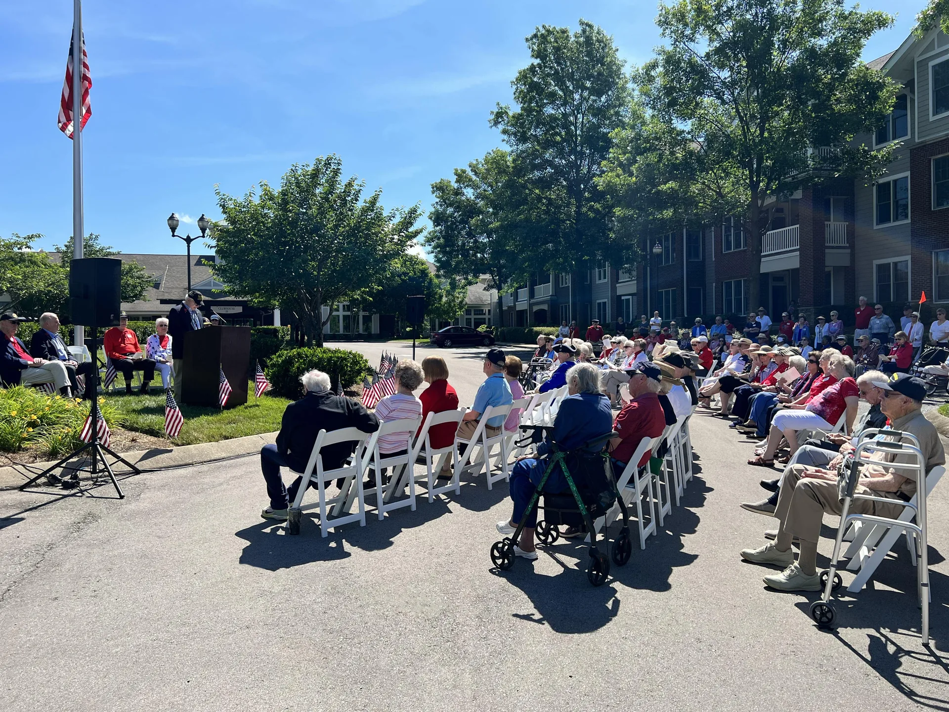 Memorial Day veterans ceremony with outdoor PA system, audio mixer and seated audience