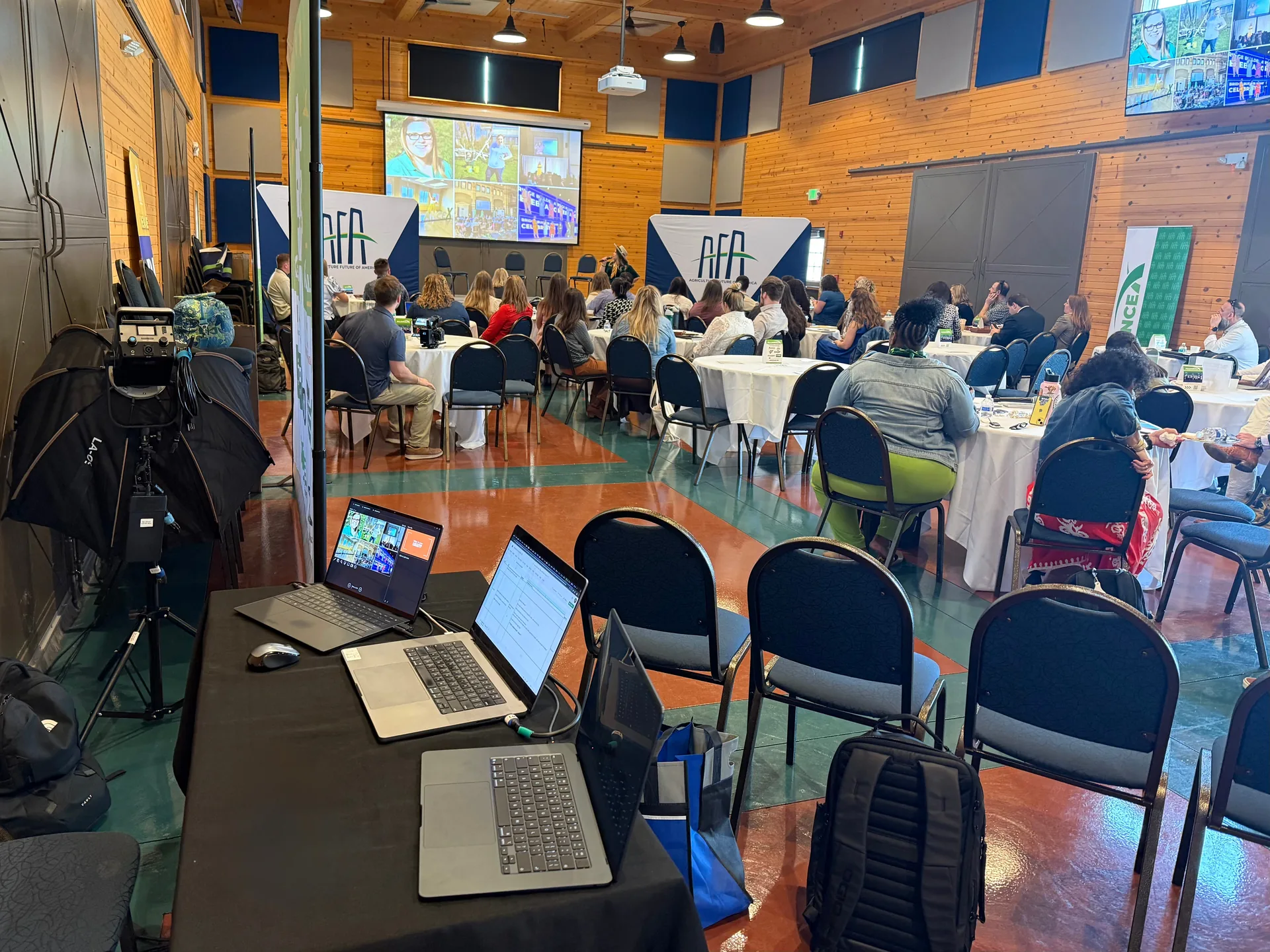 AV production setup at a corporate event in Nashville with round tables, projection screen and audience seating