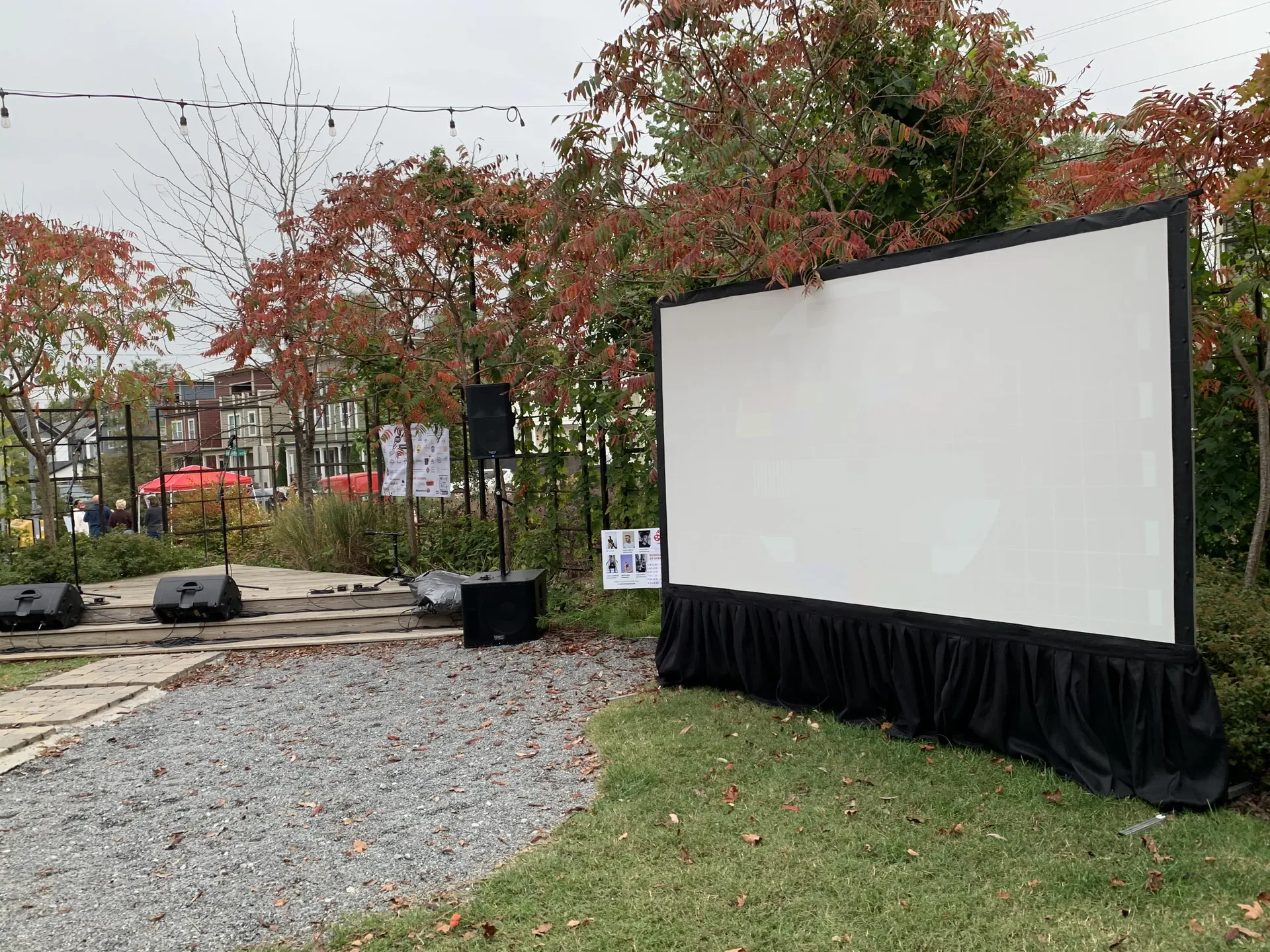 Outdoor cinema screen set up in a park with autumn foliage
