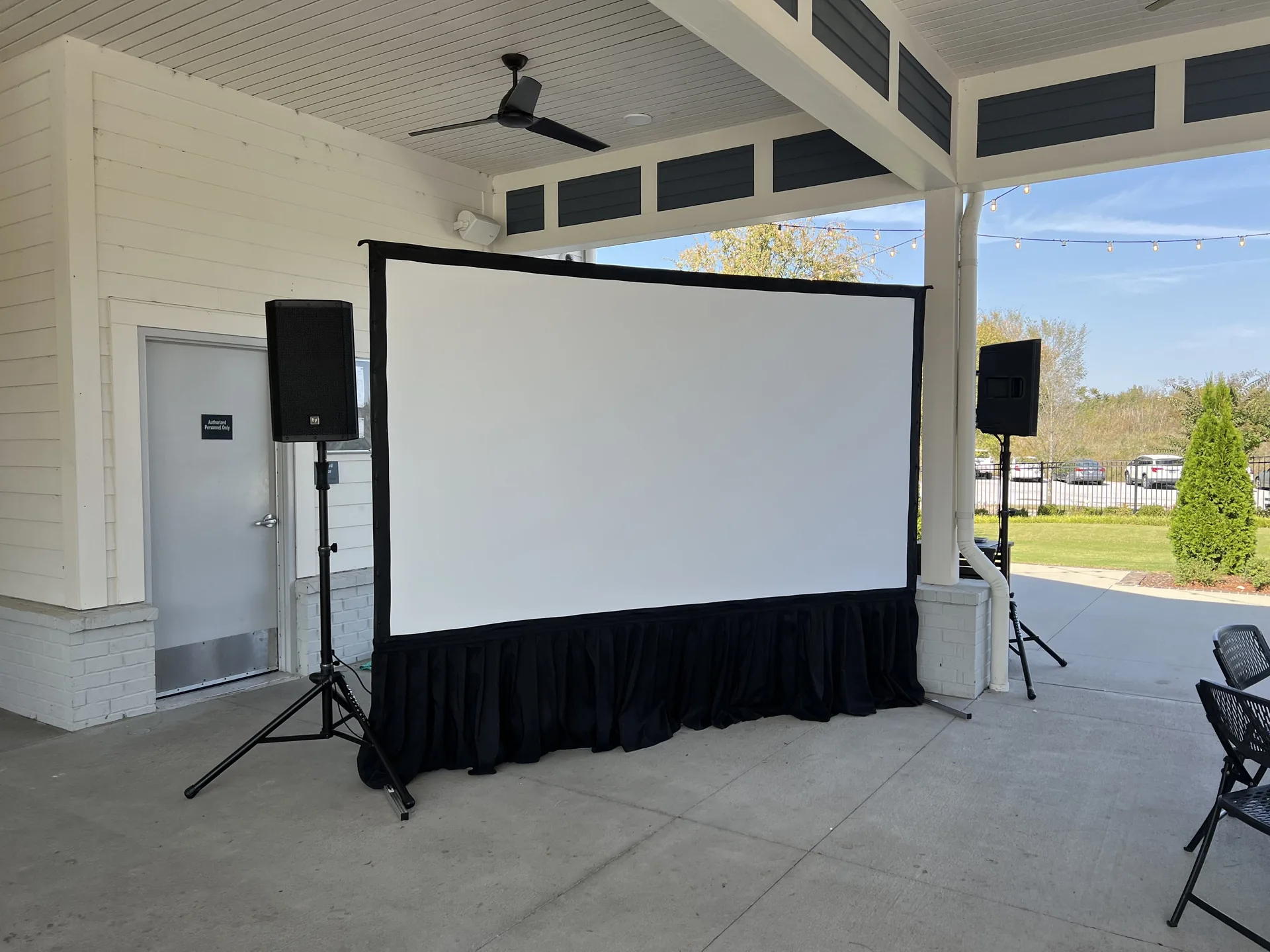 Outdoor AV setup with a large projector screen and EV speakers for a Nashville event