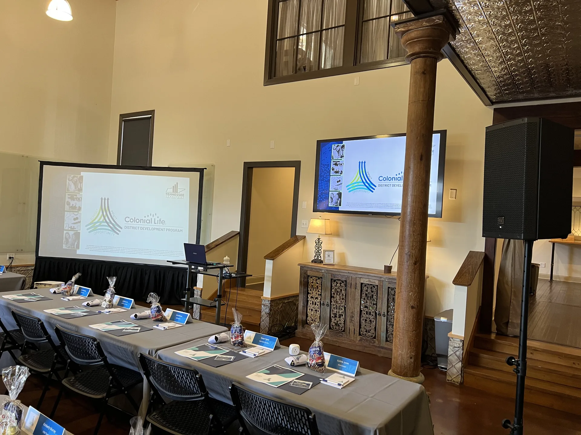 Professional development seminar in a rustic venue with projection screens and PA audio support